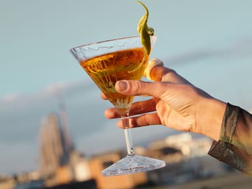 a hand holding a glass of liquid