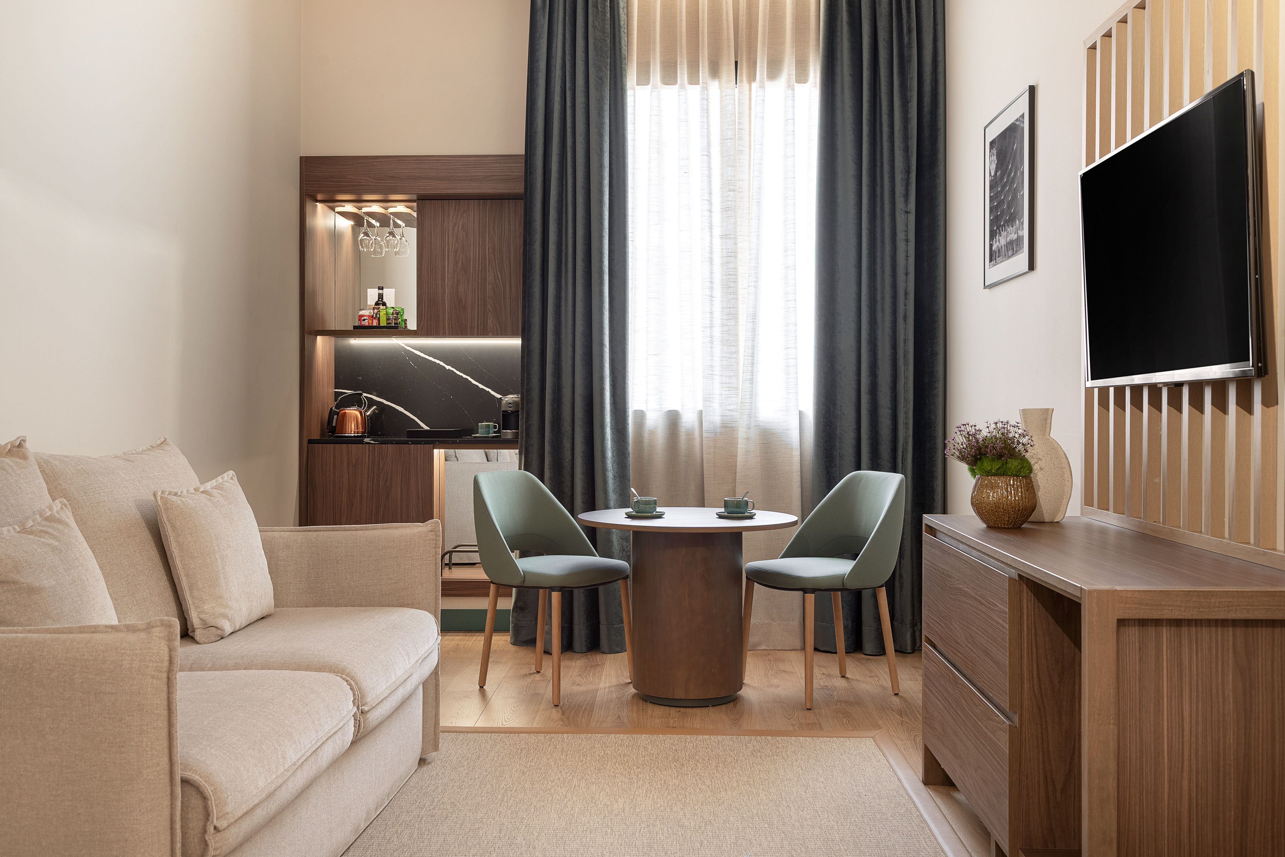 Modern studio apartment living space with kitchenette and dining area.