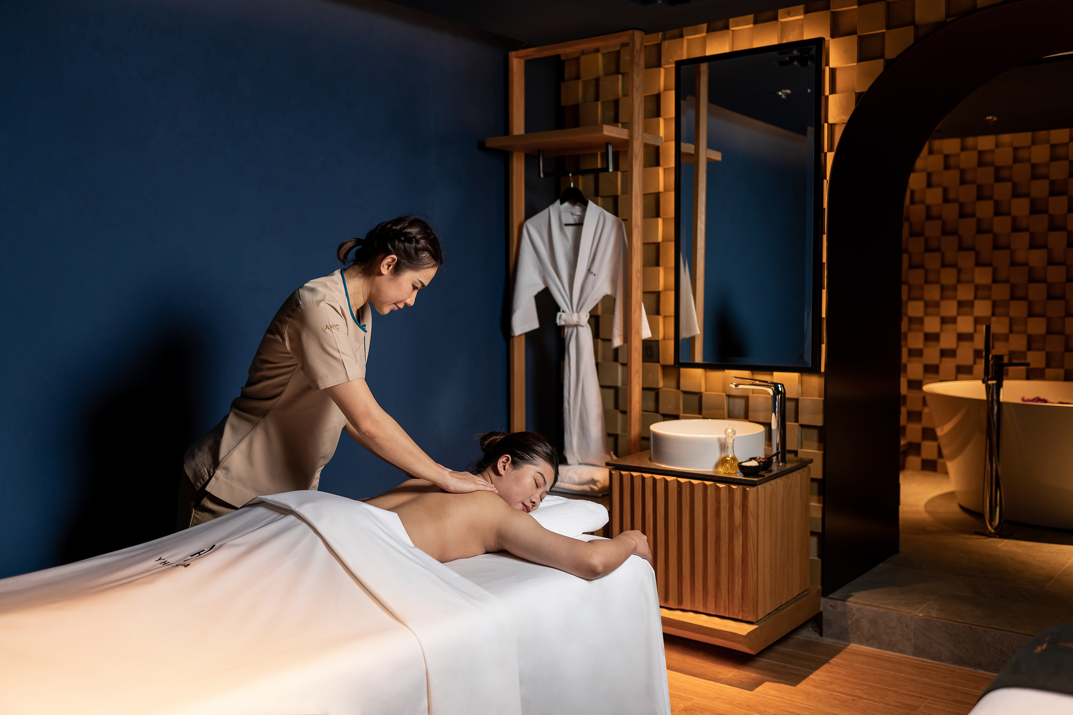 Therapist giving a relaxing back massage in a luxurious spa room.