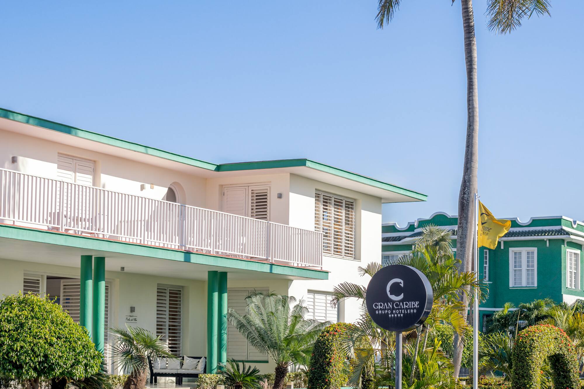 a building with a palm tree and a sign