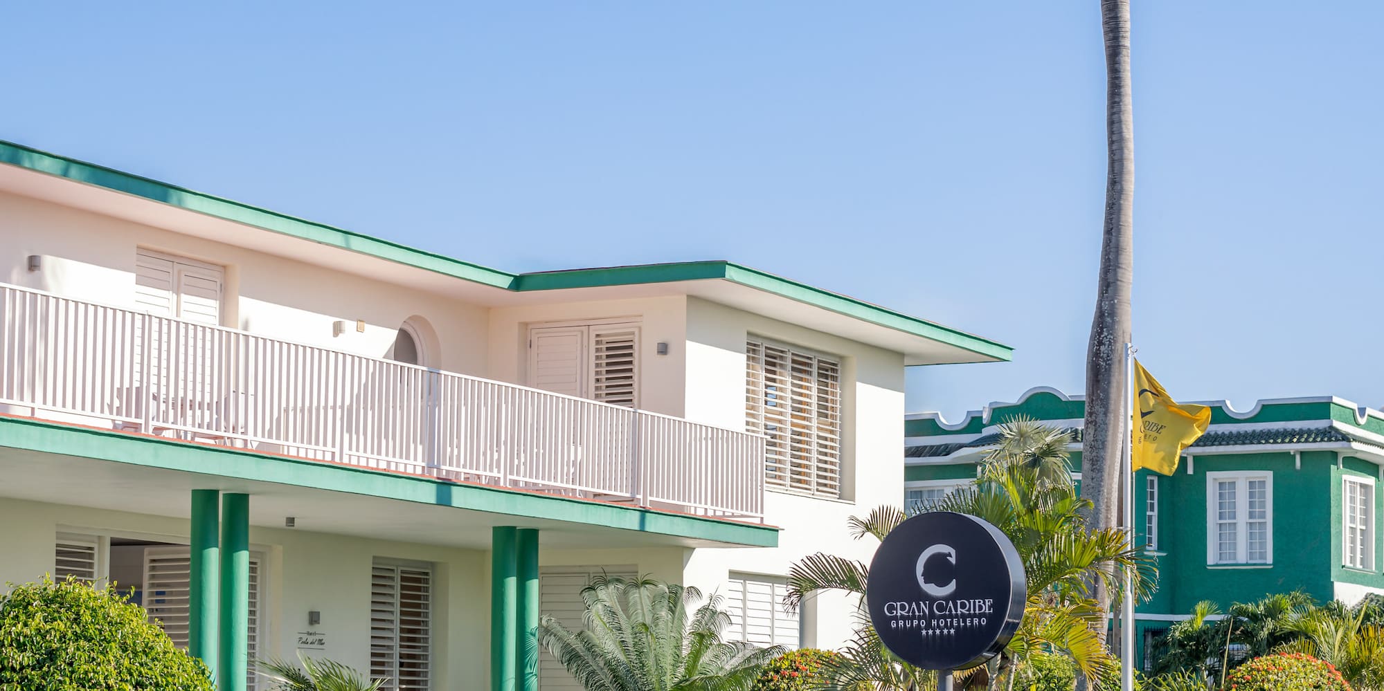a building with a palm tree and a sign