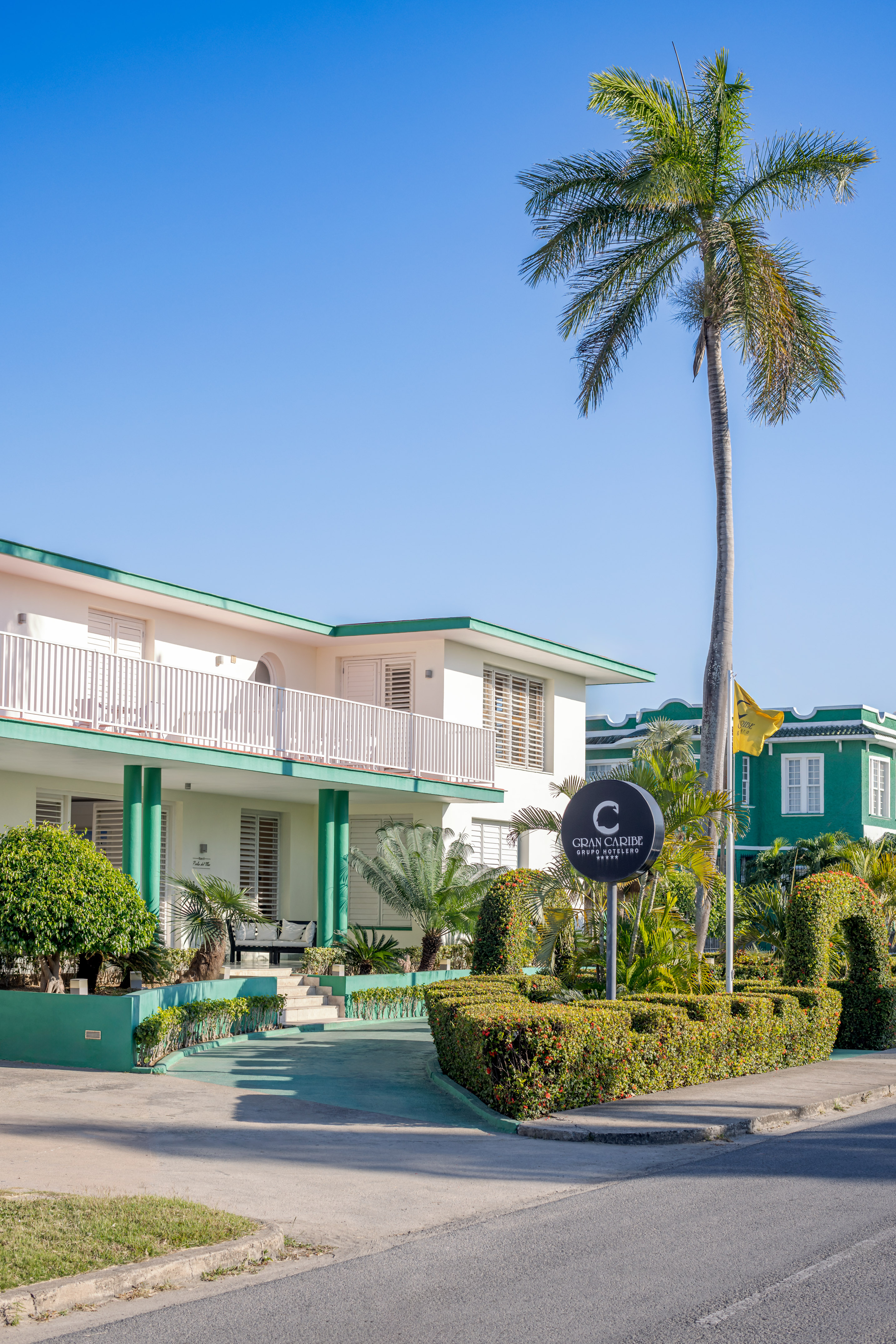 a building with a palm tree and a sign