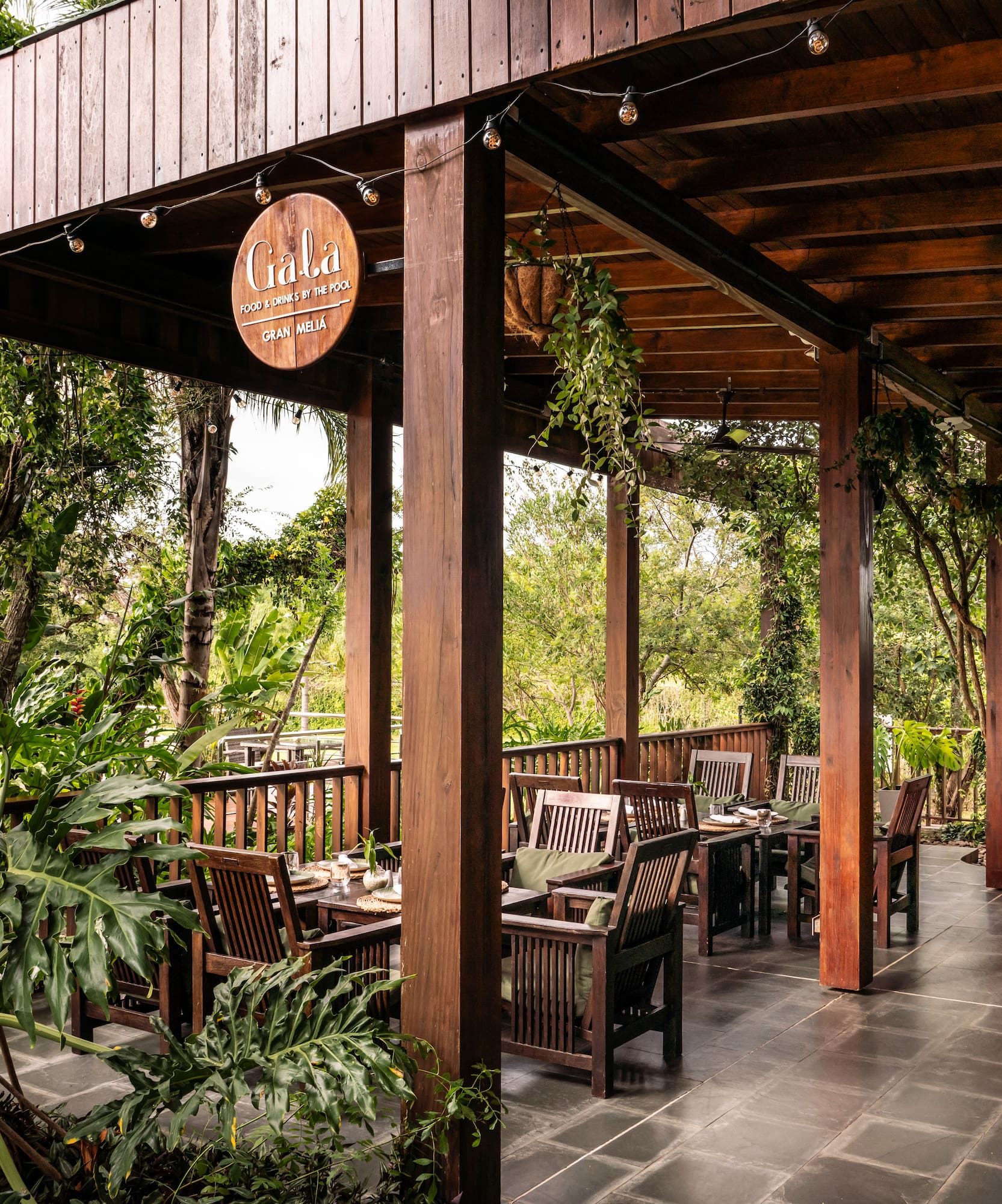 a wooden covered patio with chairs and tables
