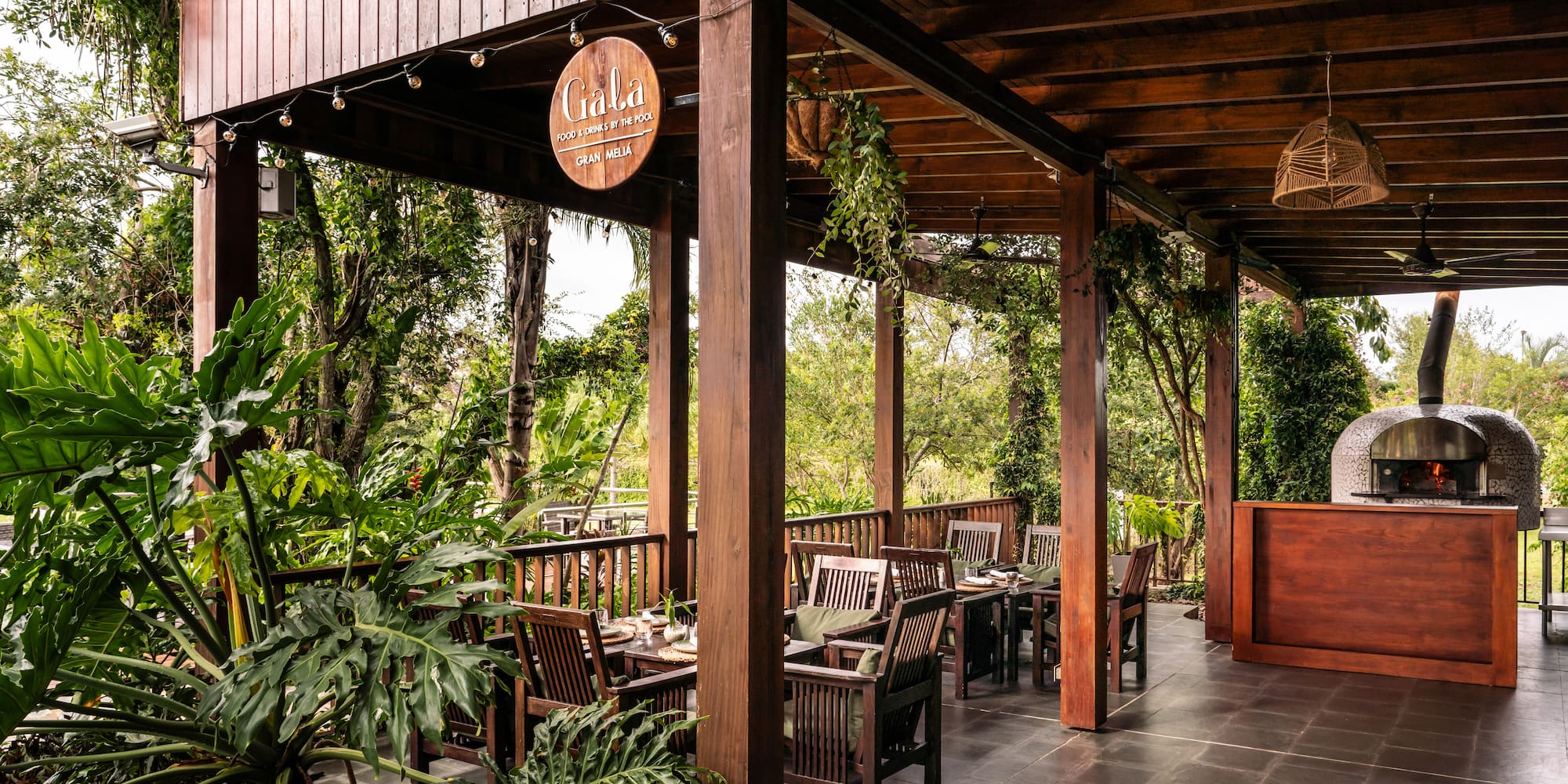 a wooden covered patio with chairs and tables