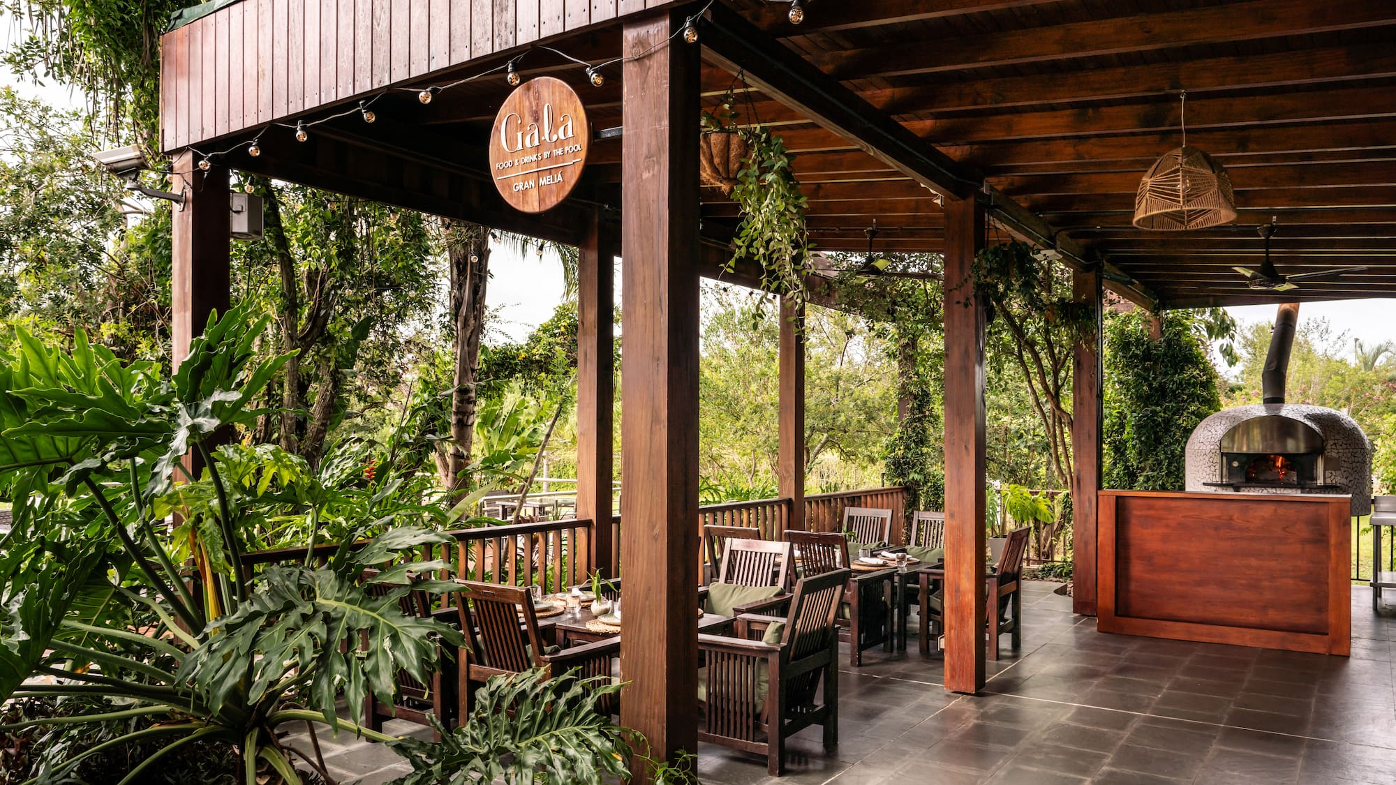 a wooden covered patio with chairs and tables