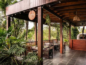 a wooden covered patio with chairs and tables