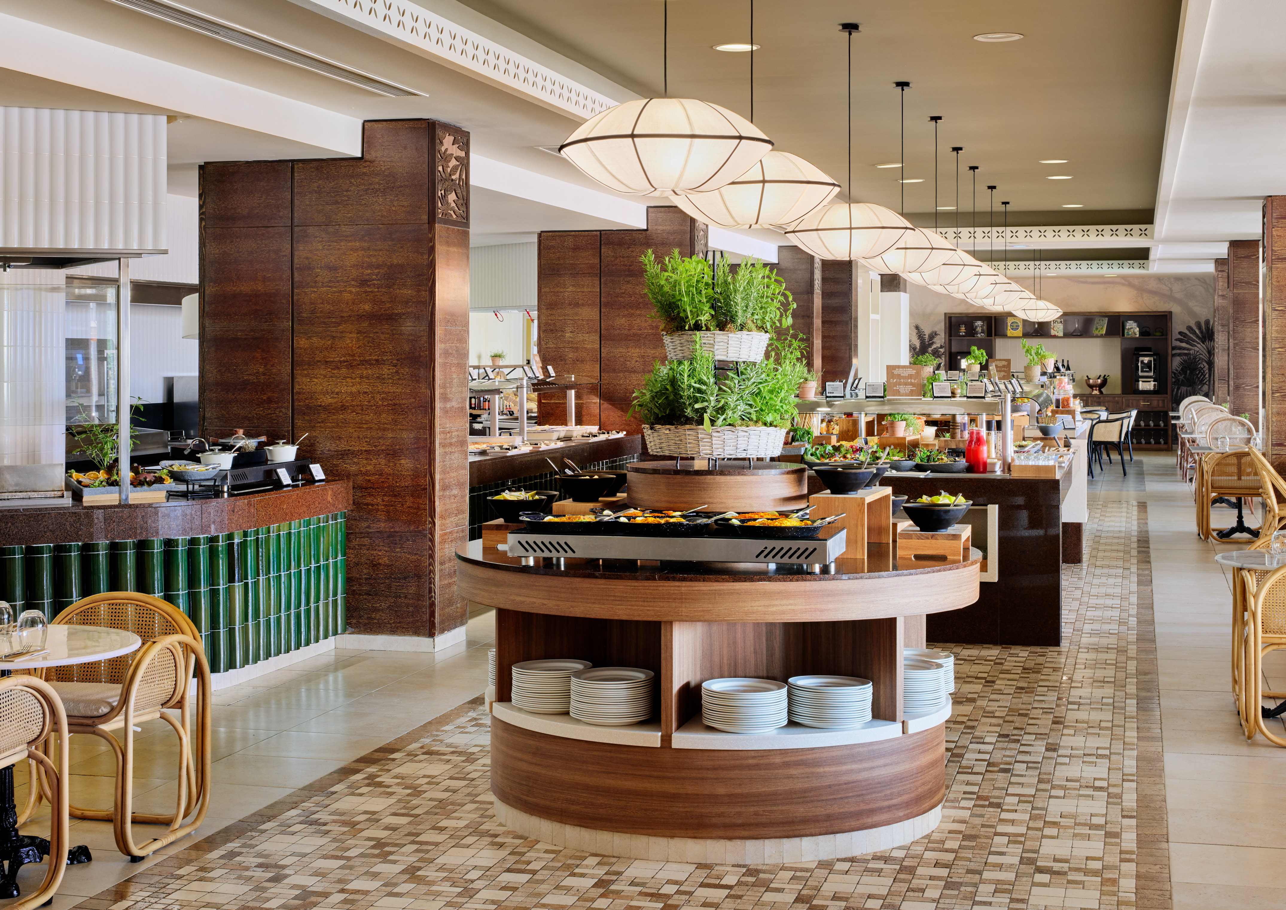 Hotel buffet restaurant with fresh food stations, wood, and rattan decor.