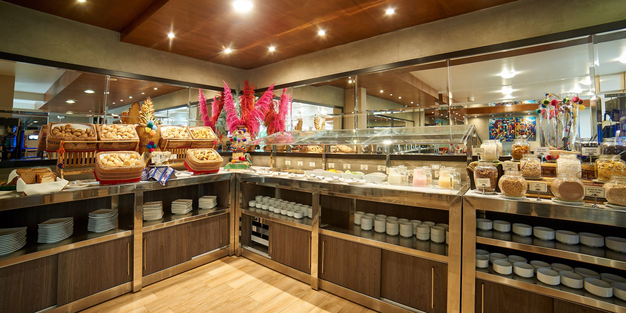 Hotel breakfast buffet showcasing bread, pastries, cereals, and milk.