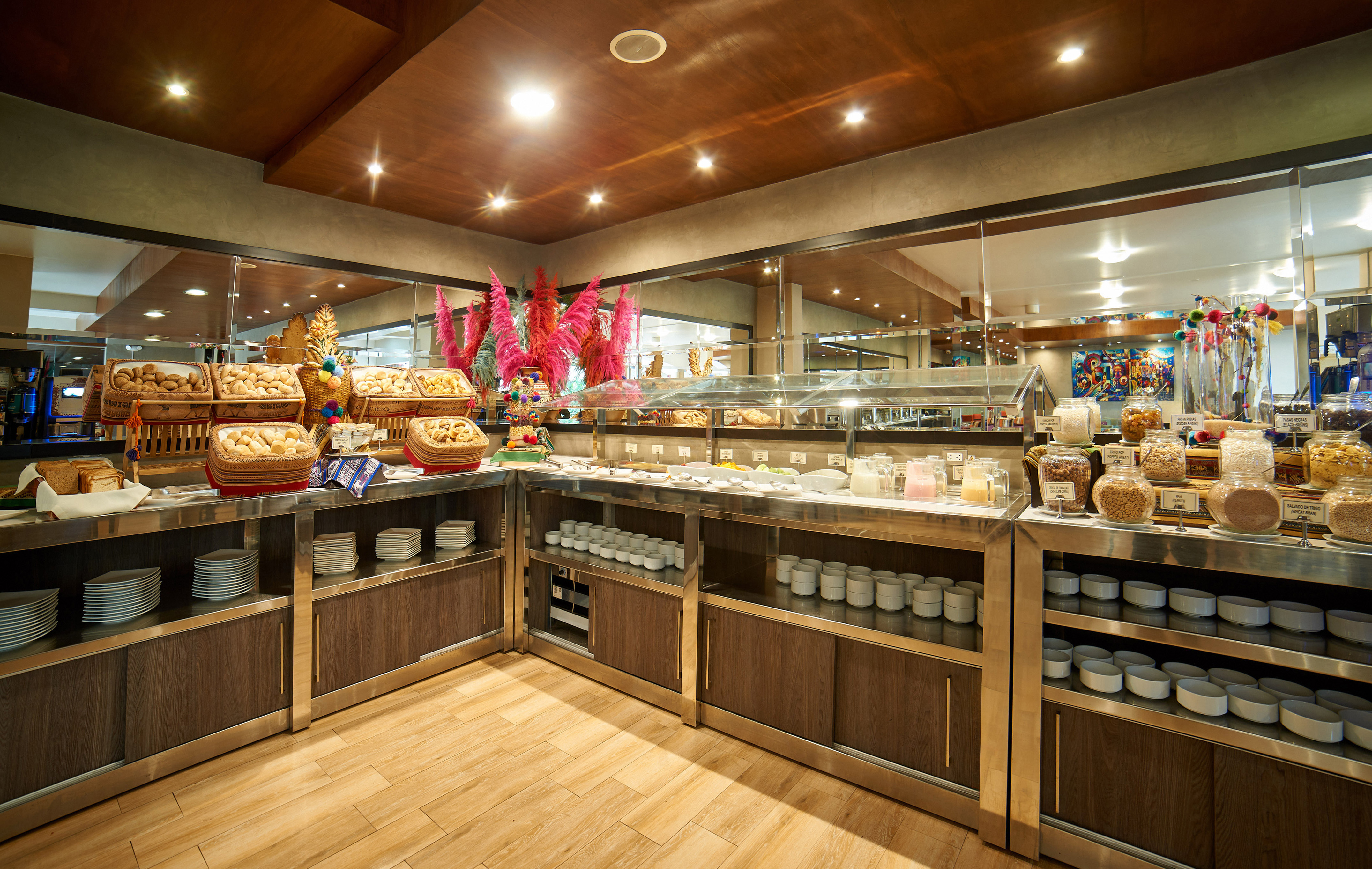 Hotel breakfast buffet showcasing bread, pastries, cereals, and milk.