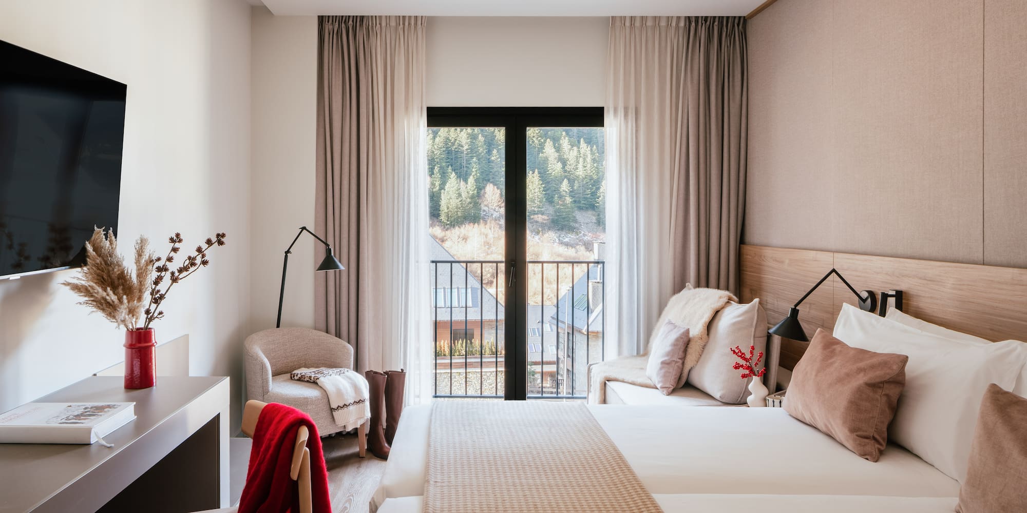 Cozy hotel bedroom with mountain view balcony, twin beds, and modern decor.