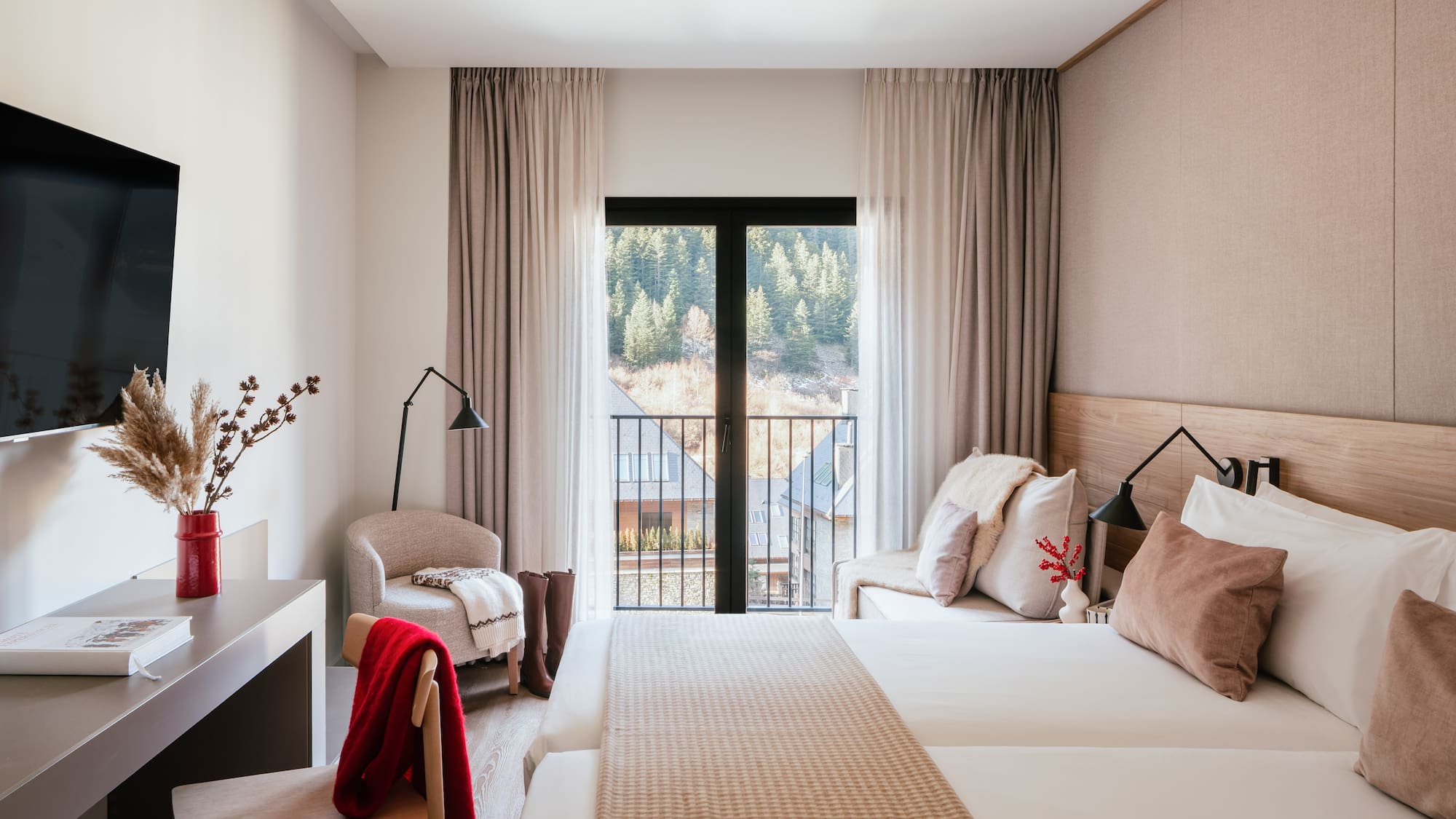 Cozy hotel bedroom with mountain view balcony, twin beds, and modern decor.