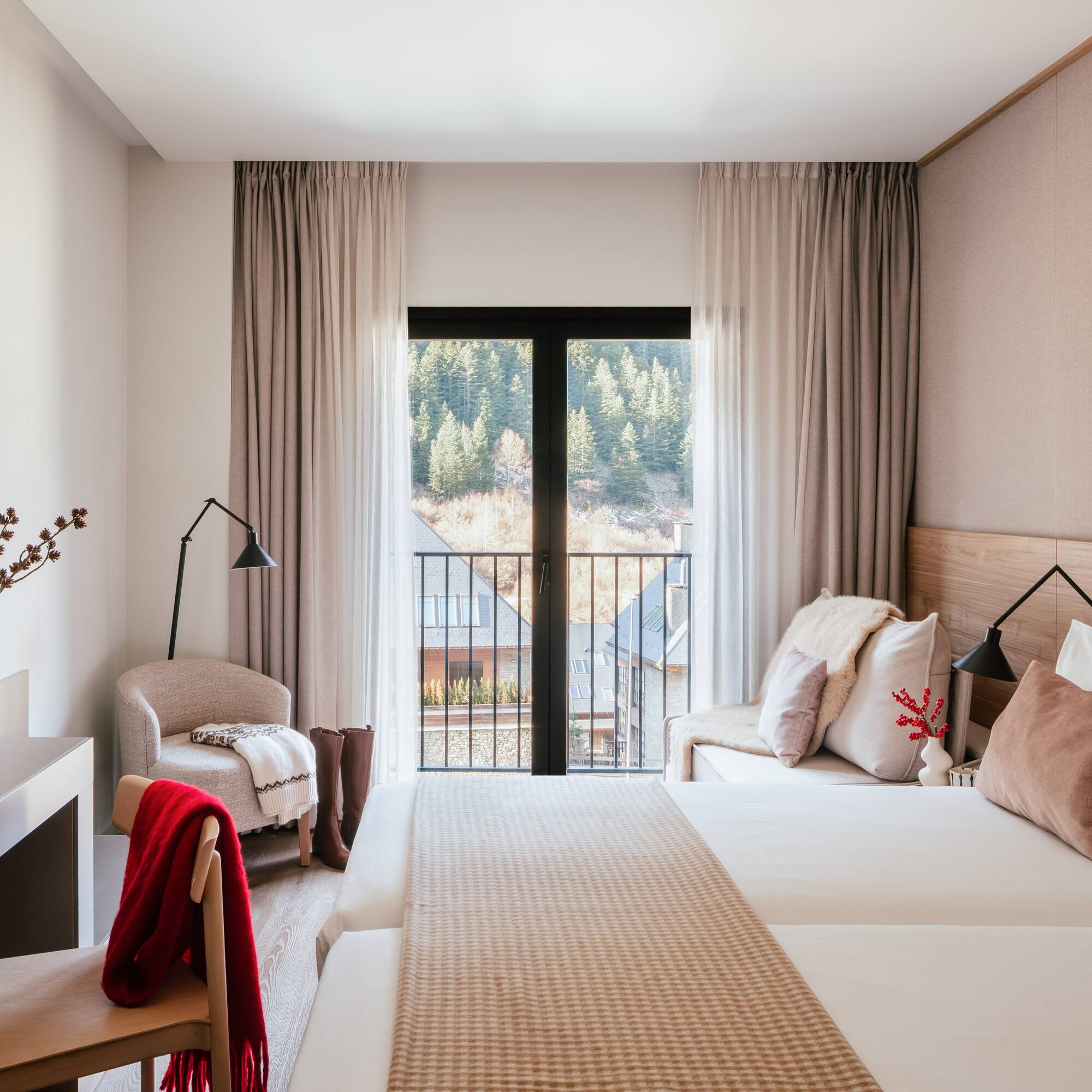 Cozy hotel bedroom with mountain view balcony, twin beds, and modern decor.
