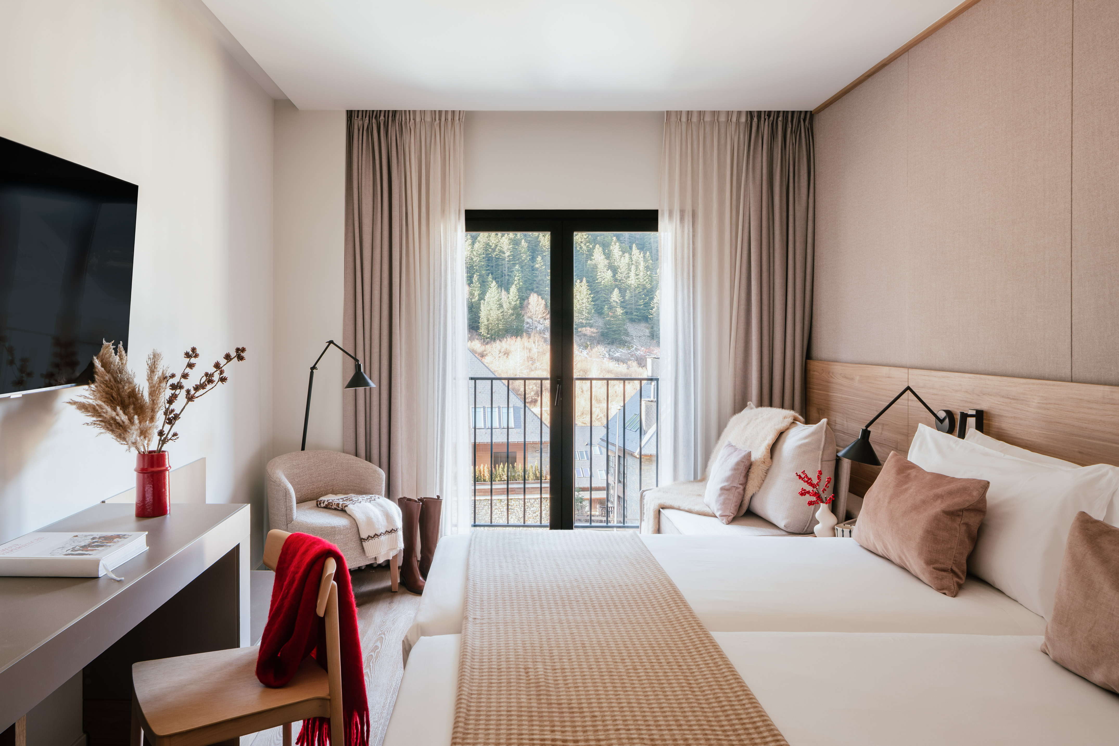 Cozy hotel bedroom with mountain view balcony, twin beds, and modern decor.