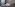 a bed with pillows and a lamp in a room