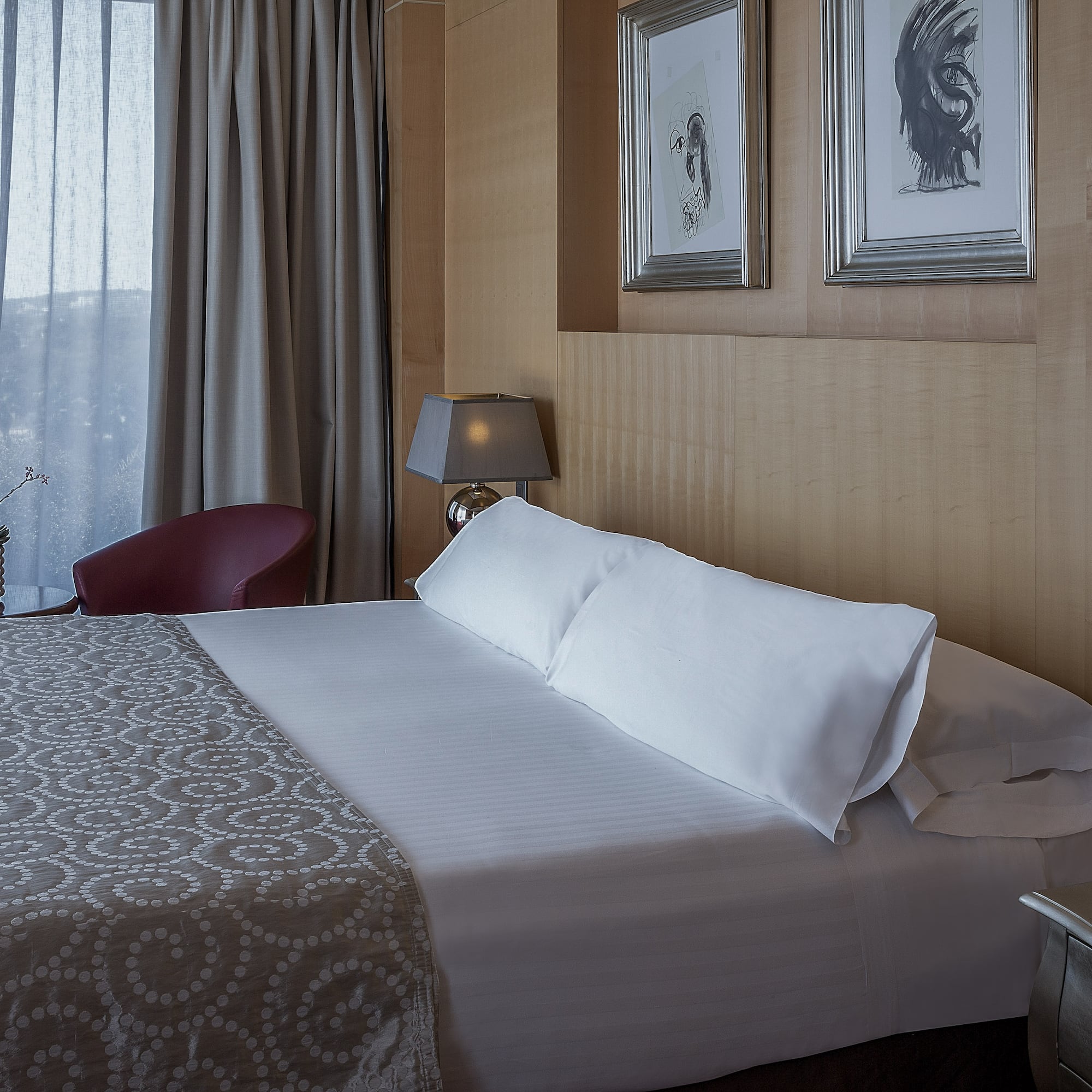 a bed with pillows and a lamp in a room