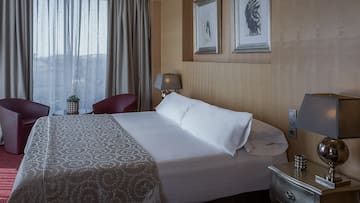 a bed with pillows and a lamp in a room