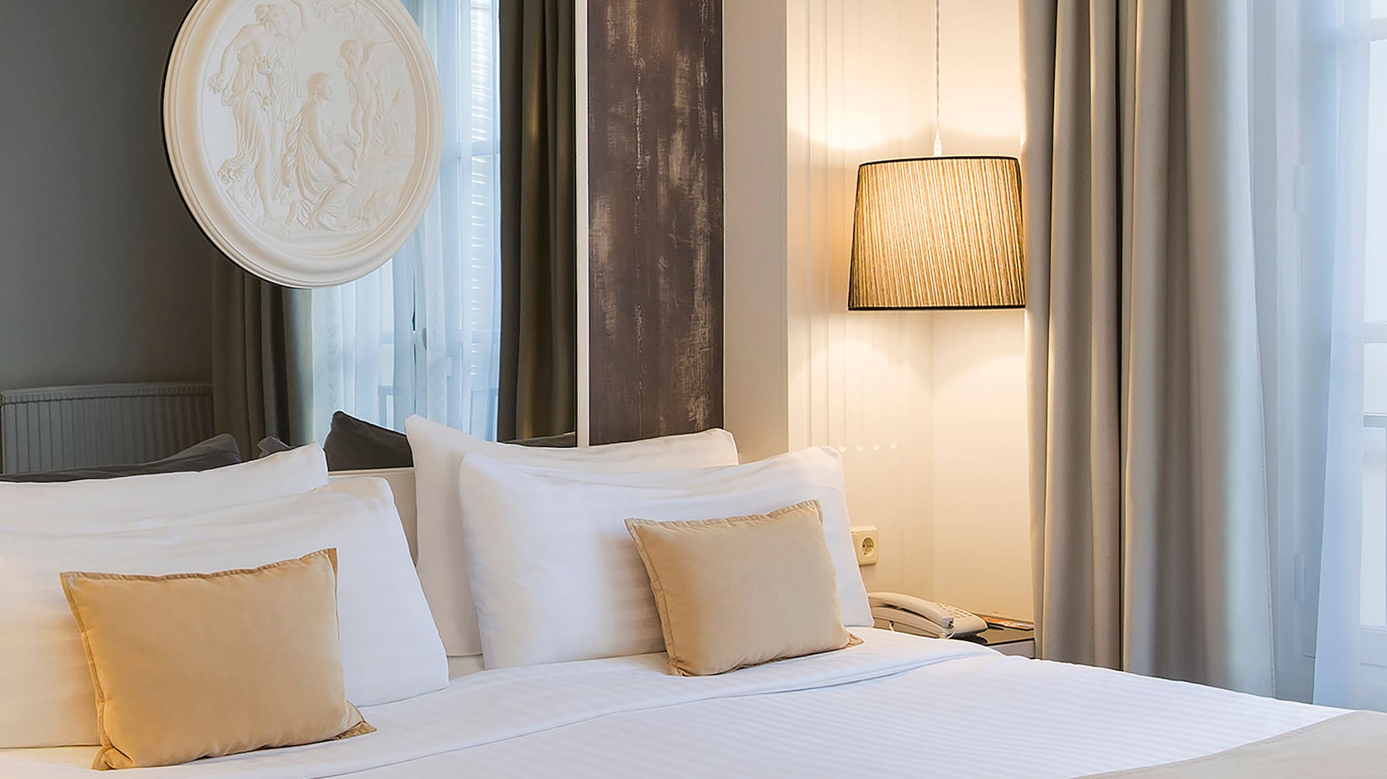 a bed with white sheets and pillows