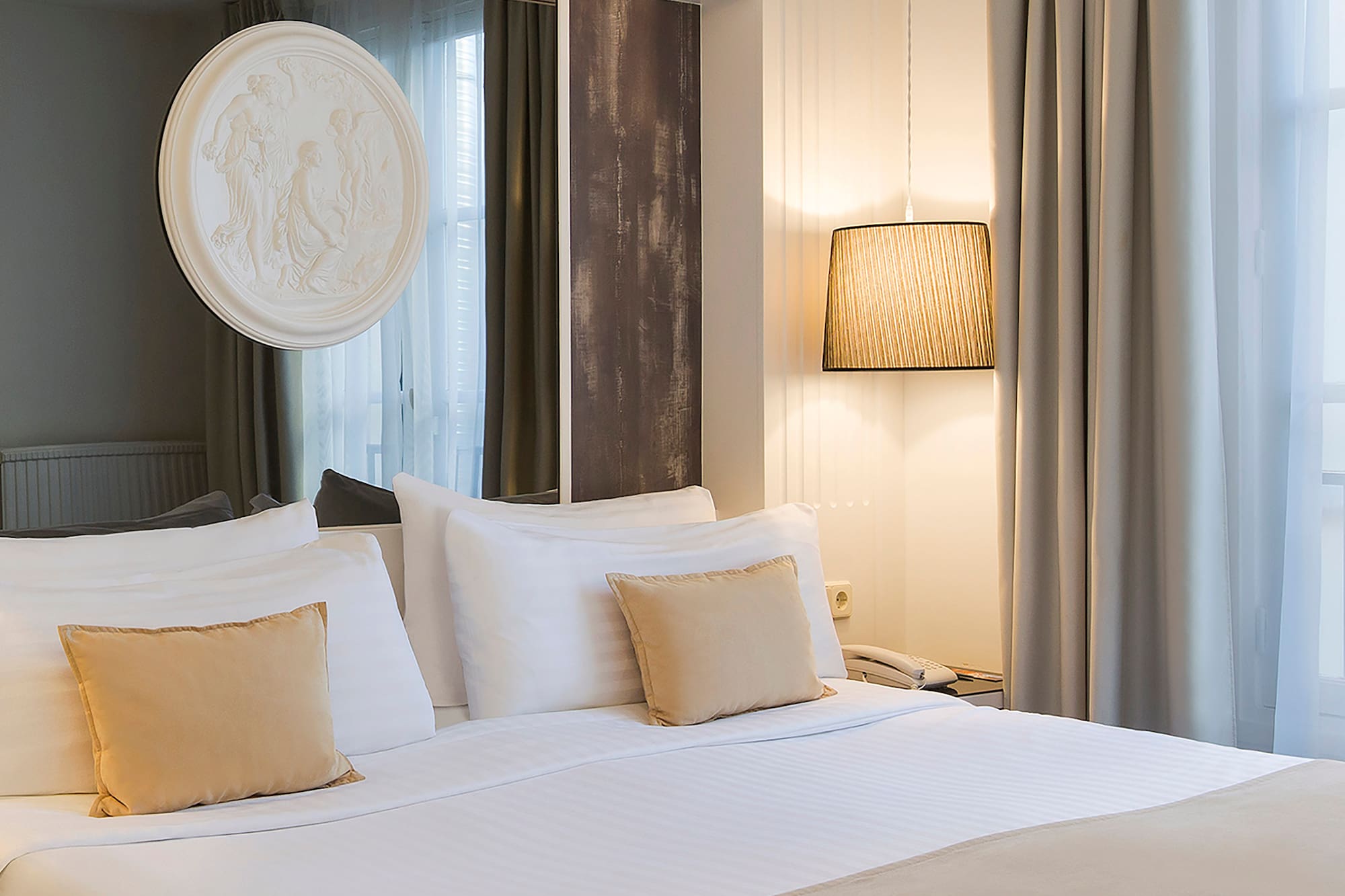 a bed with white sheets and pillows