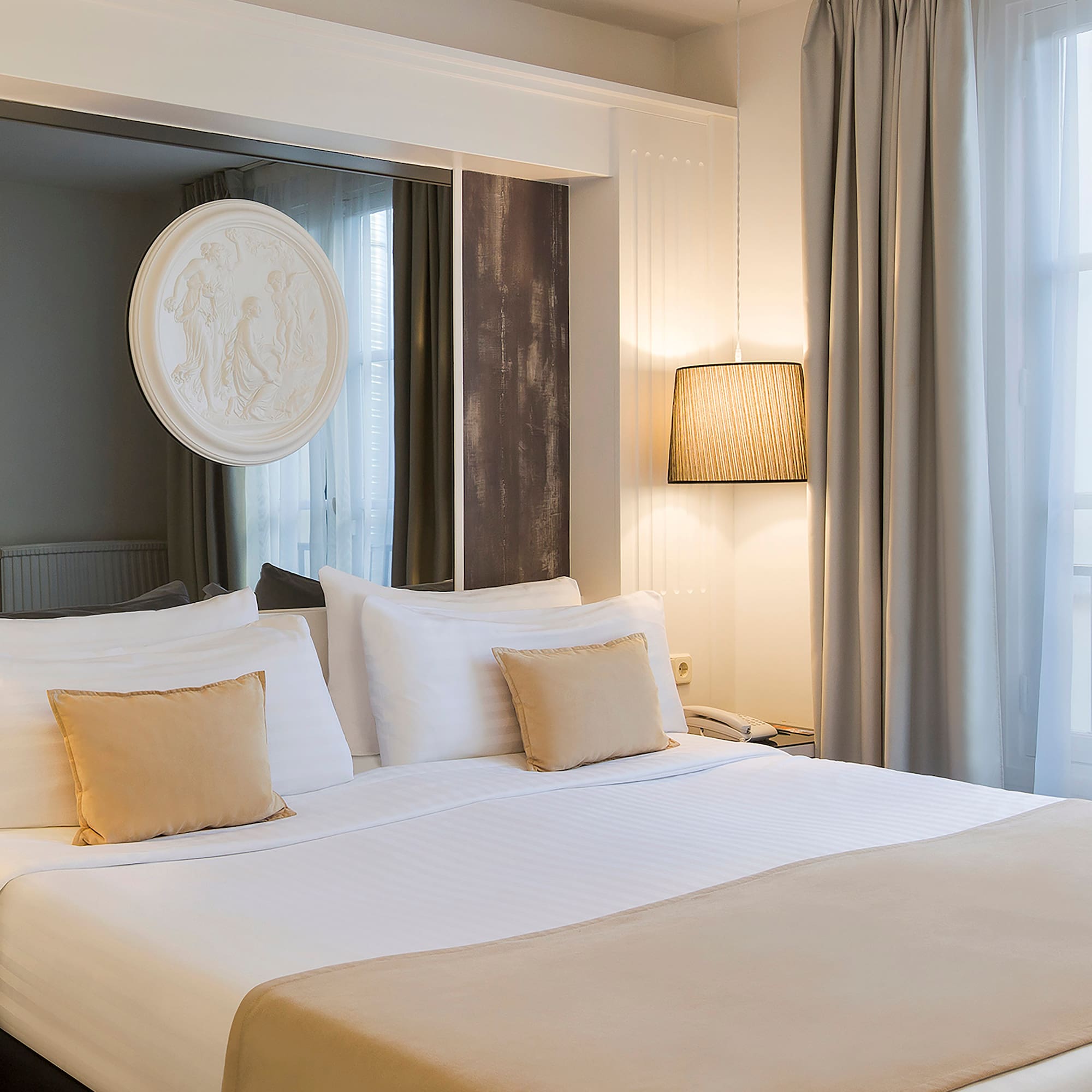 a bed with white sheets and pillows