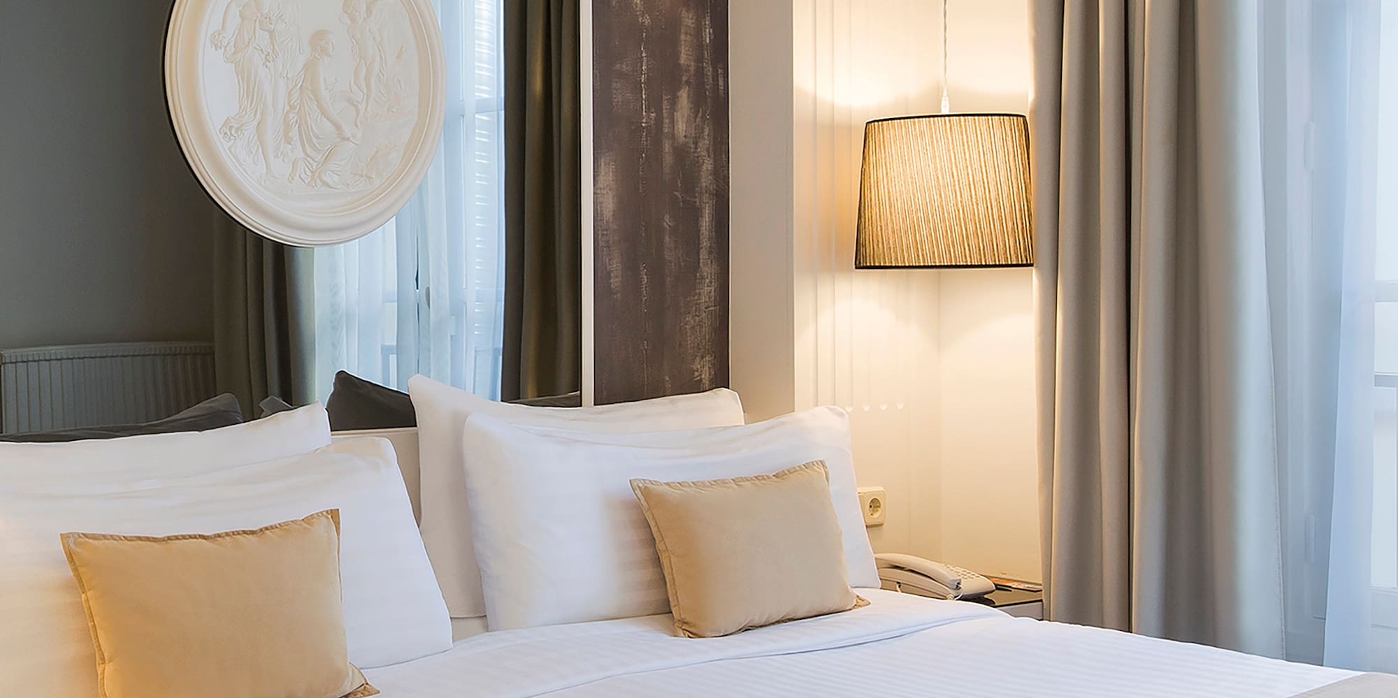 a bed with white sheets and pillows