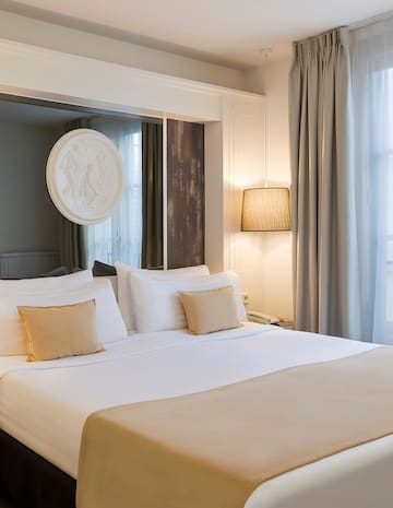 a bed with white sheets and pillows