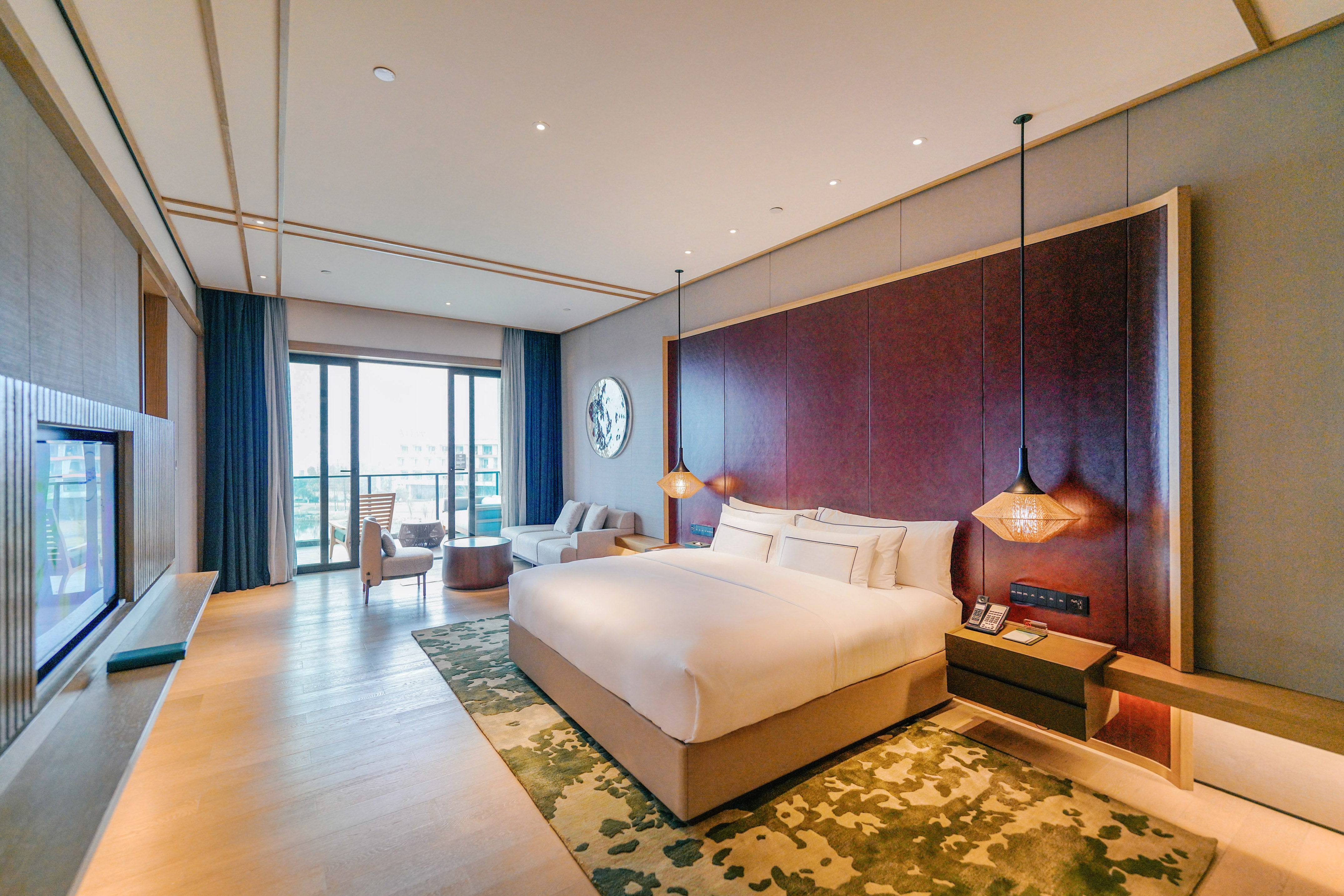 Luxury hotel bedroom suite with king bed, modern furnishings, and balcony.