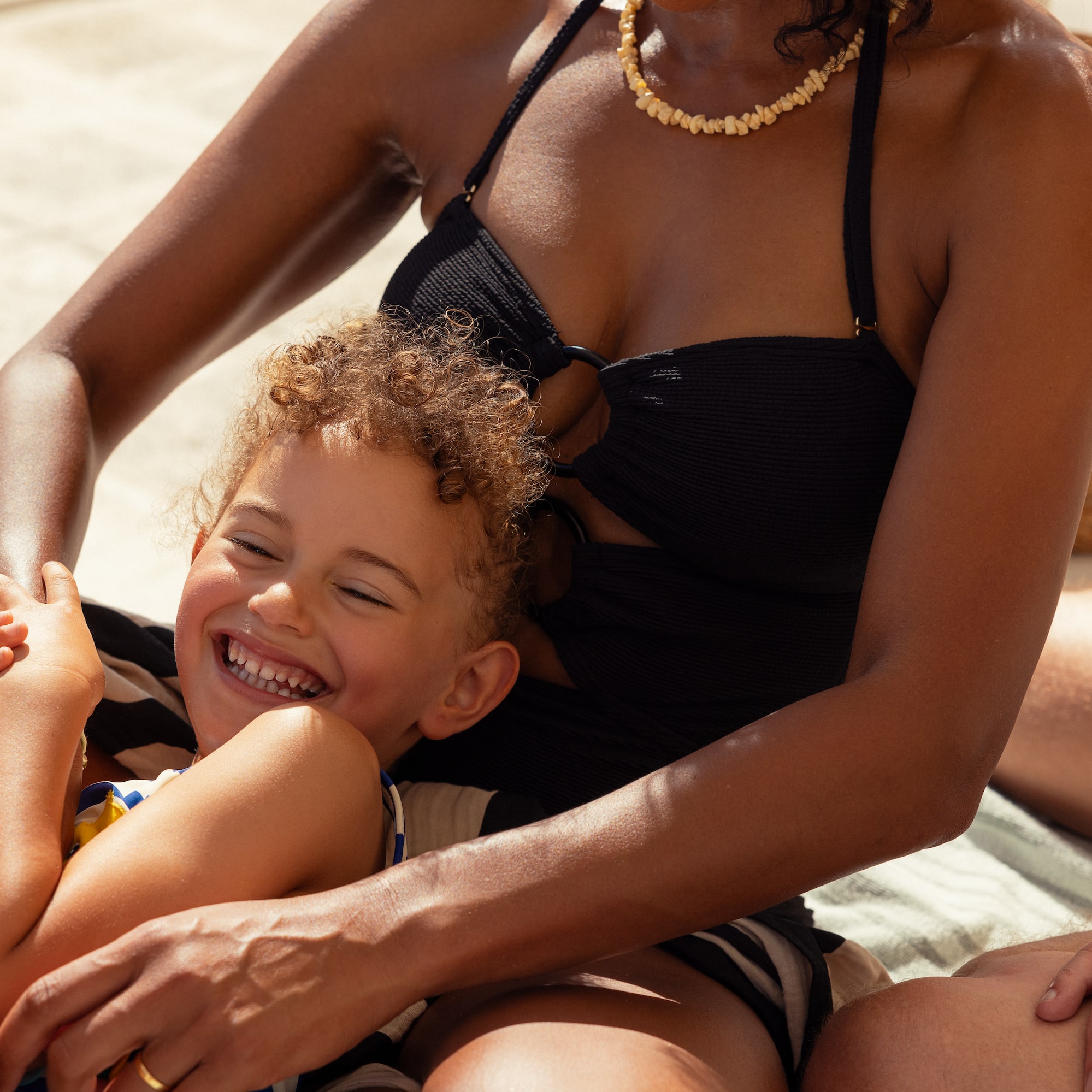 a woman and child sitting on a blanket