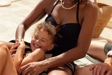 a woman and child sitting on a blanket