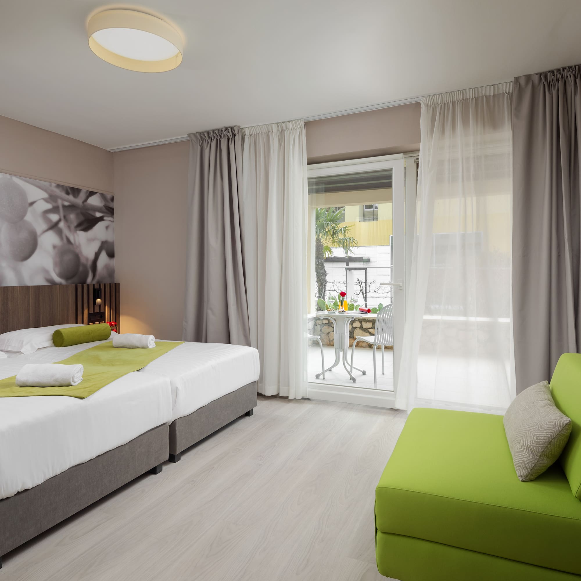 a room with two beds and a green couch