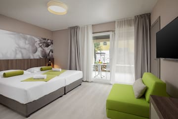 a room with two beds and a green couch