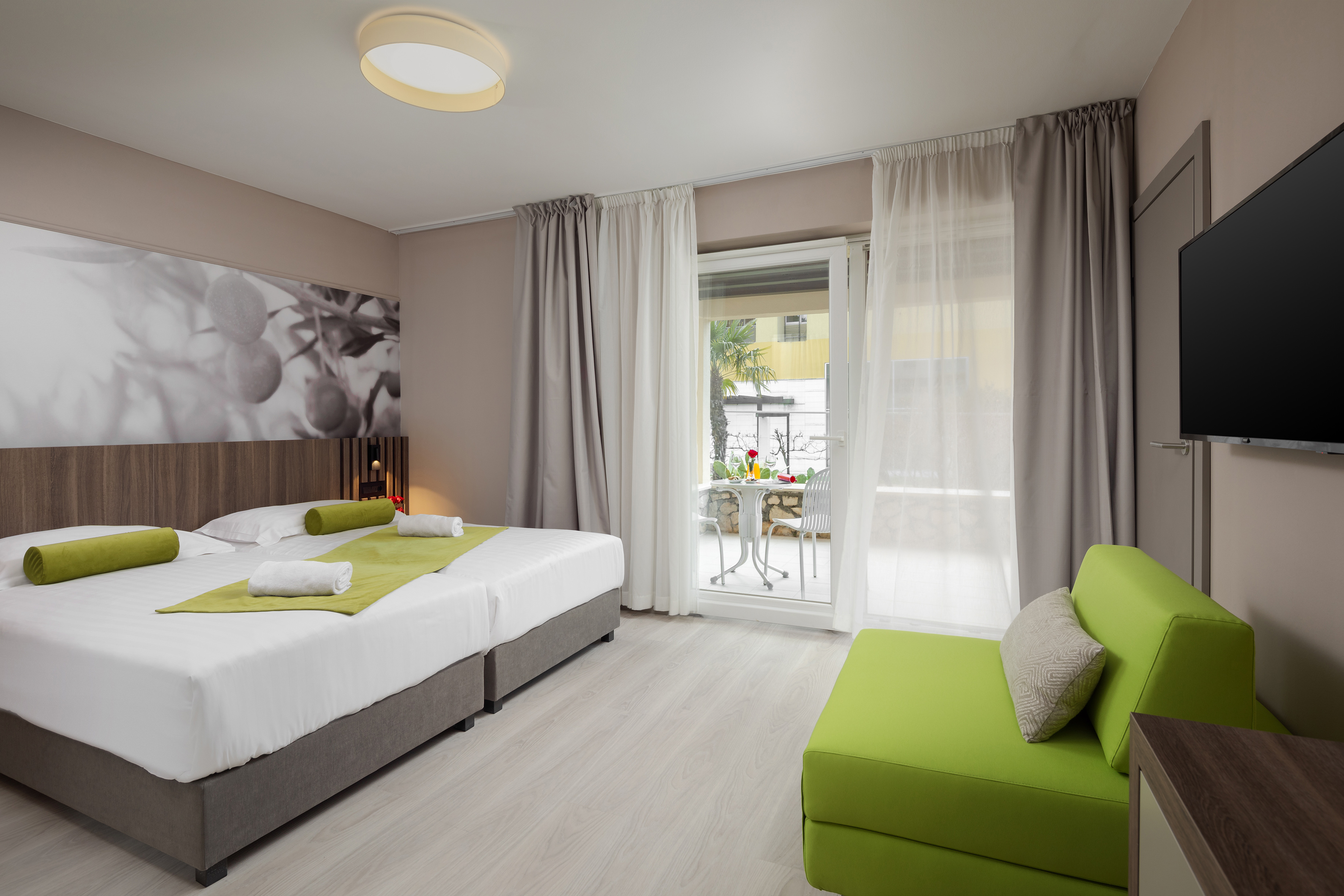 a room with two beds and a green couch