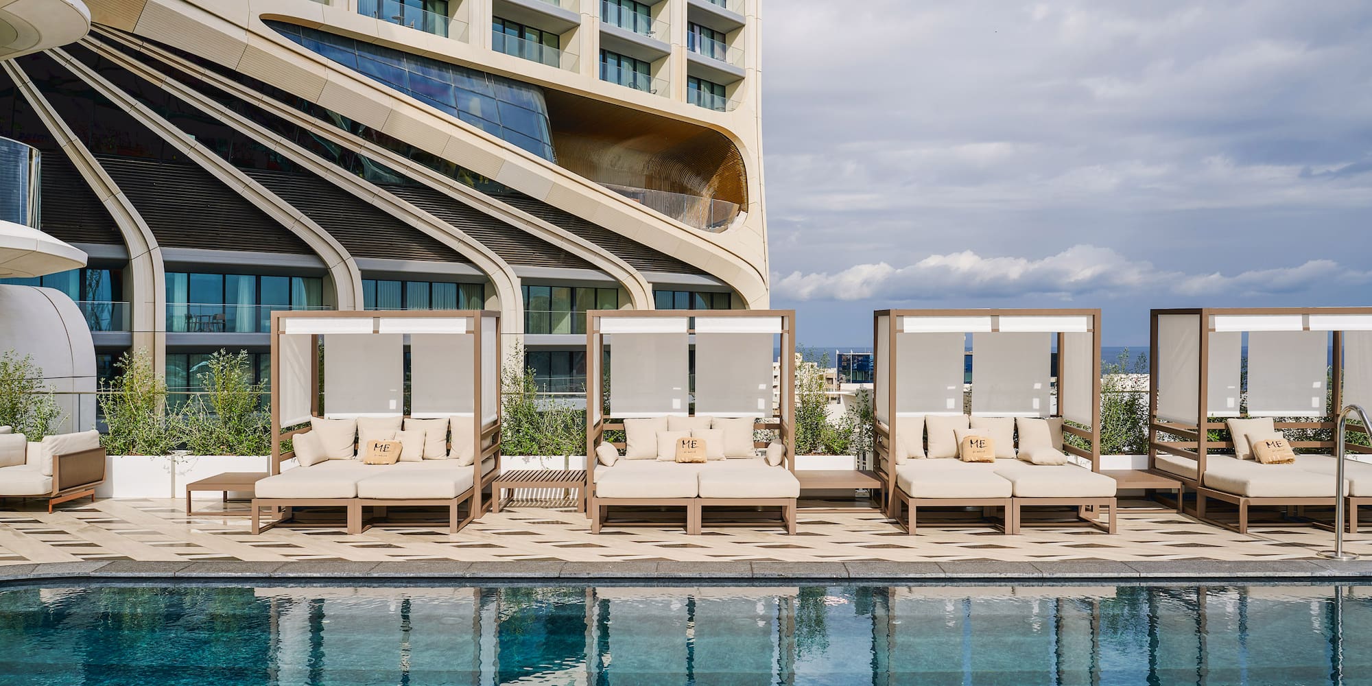 a pool with lounge chairs and a building in the background