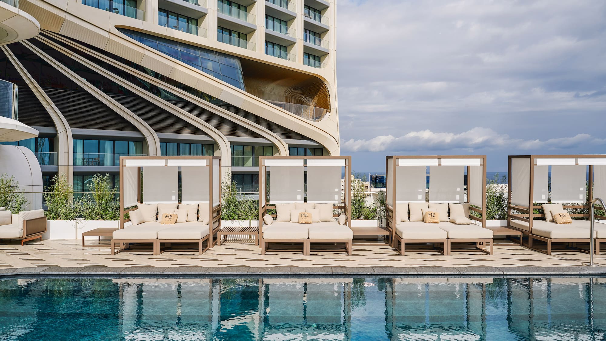 a pool with lounge chairs and a building in the background
