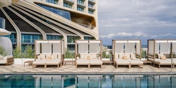 a pool with lounge chairs and a building in the background