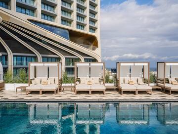 a pool with lounge chairs and a building in the background