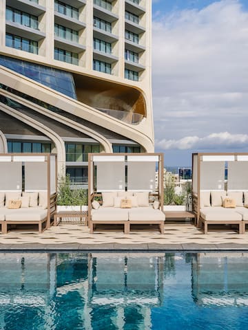 a pool with lounge chairs and a building in the background