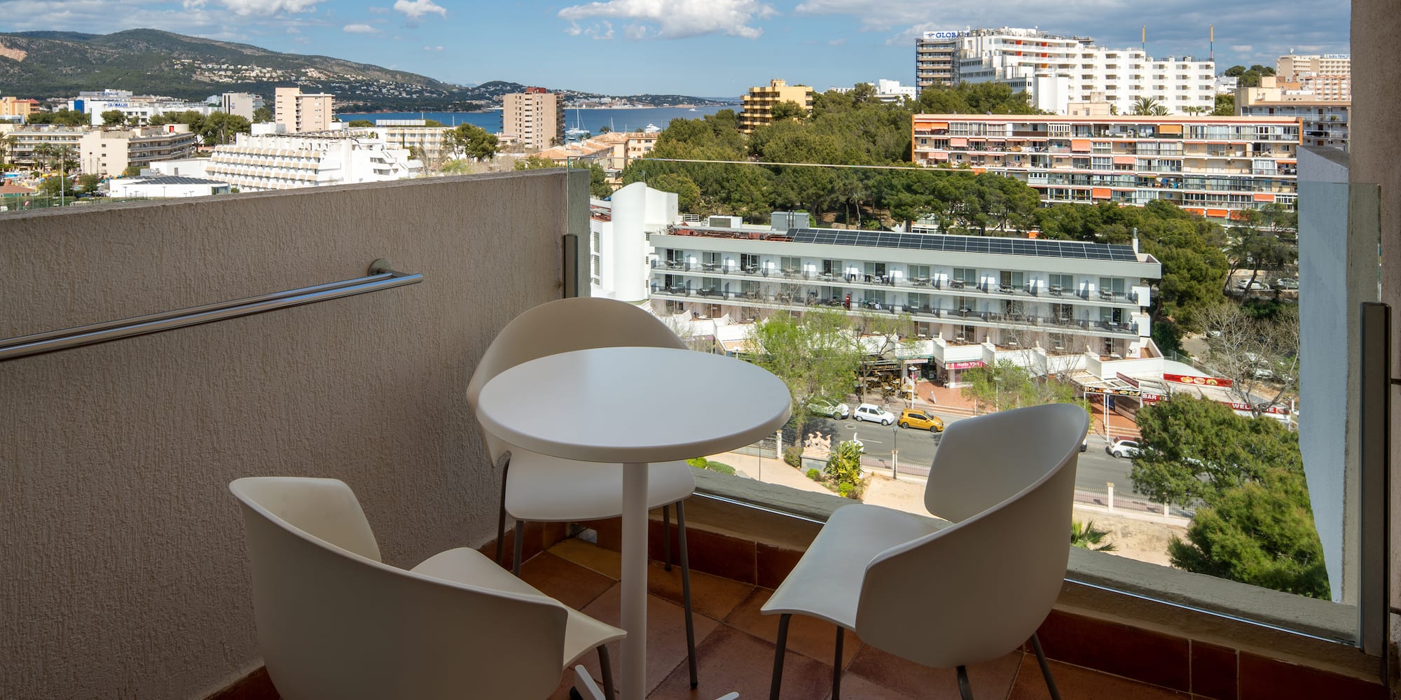 a table and chairs on a balcony overlooking a city
