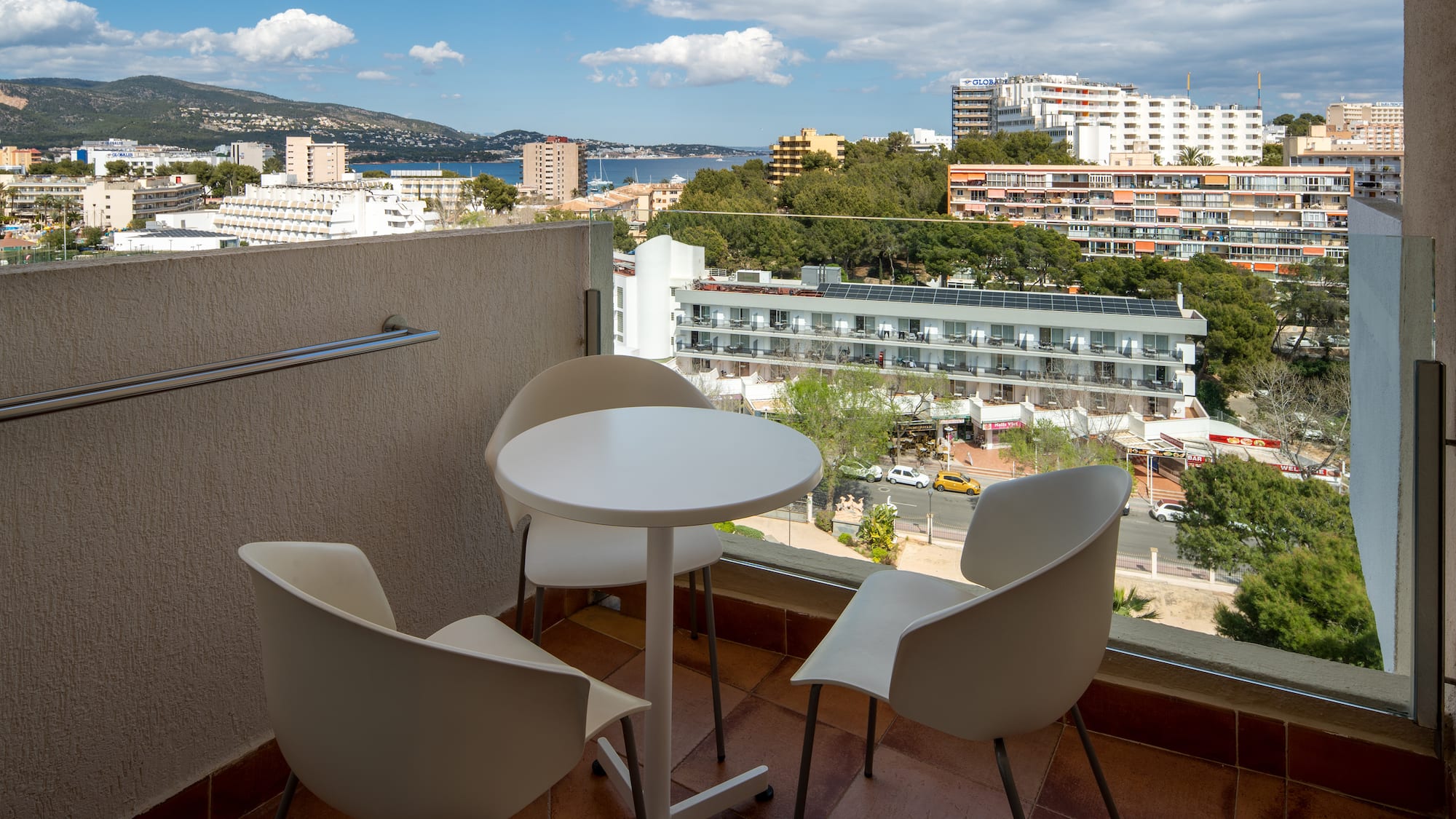 a table and chairs on a balcony overlooking a city