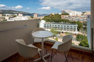 a table and chairs on a balcony overlooking a city