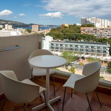 a table and chairs on a balcony overlooking a city