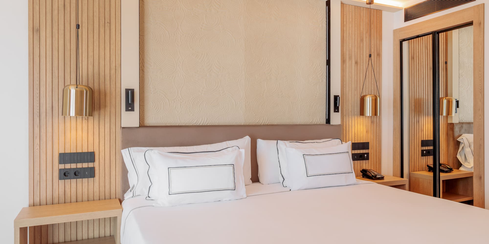 a bed with white sheets and a lamp