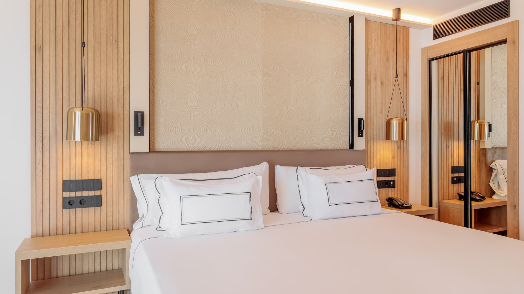 a bed with white sheets and a lamp