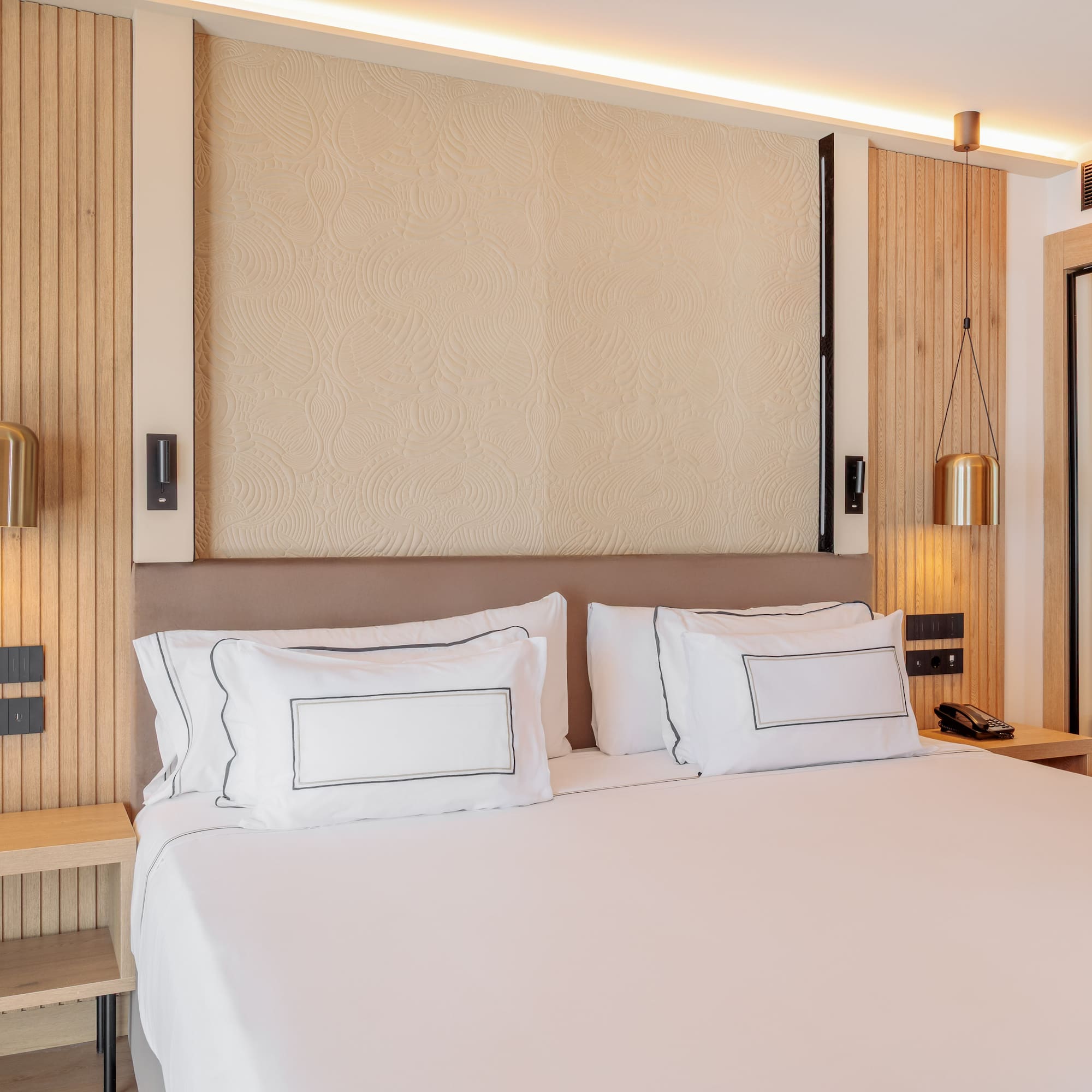 a bed with white sheets and a lamp