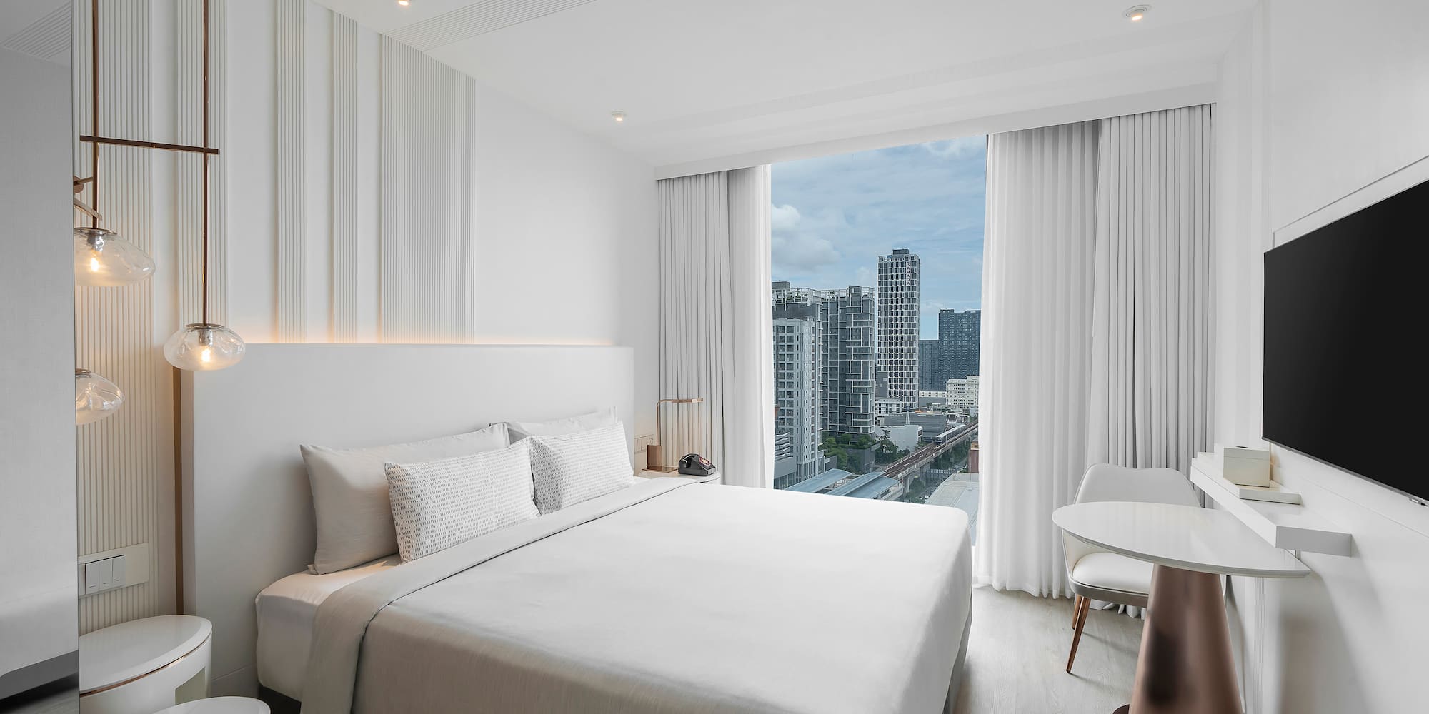 a bedroom with a large window and a city view