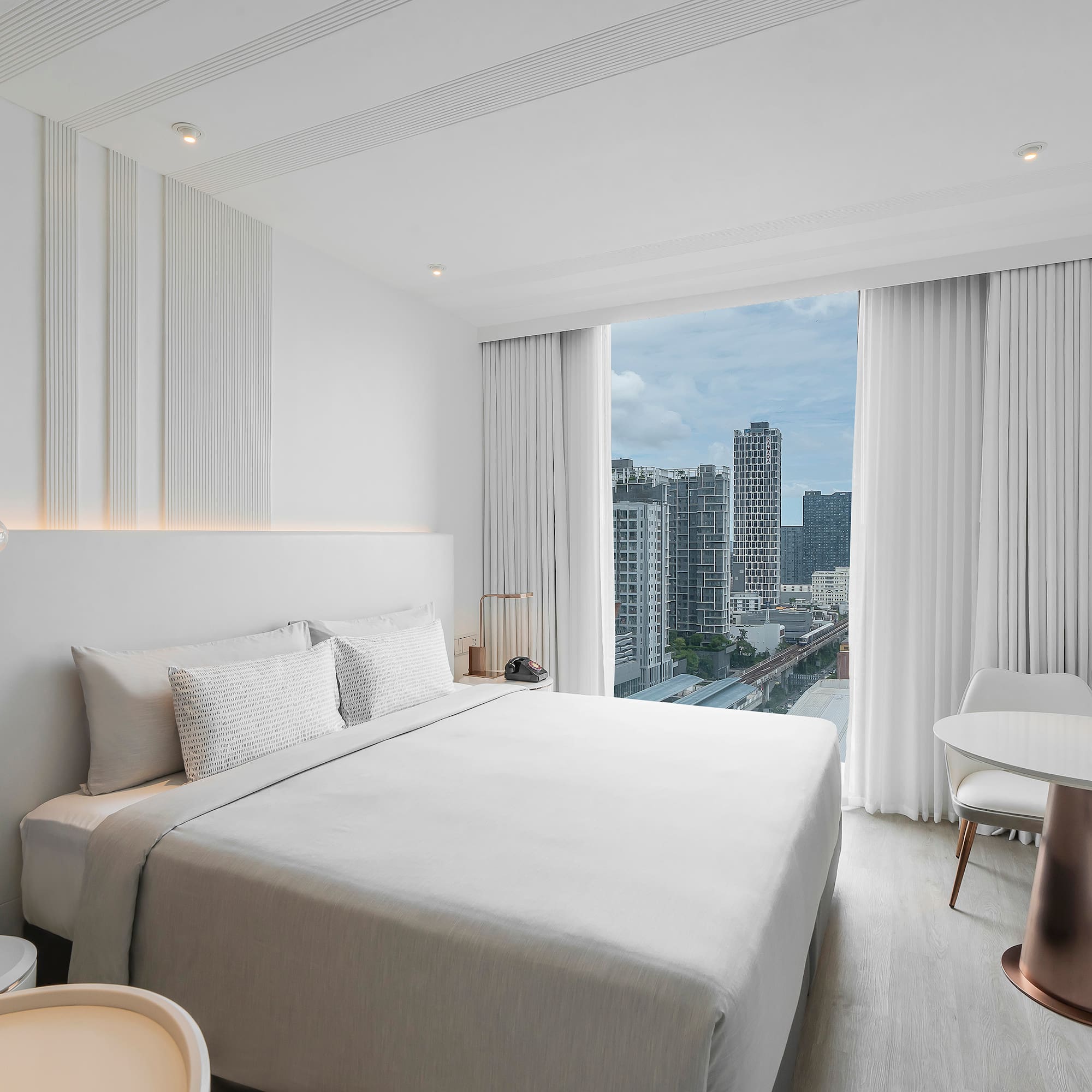 a bedroom with a large window and a city view