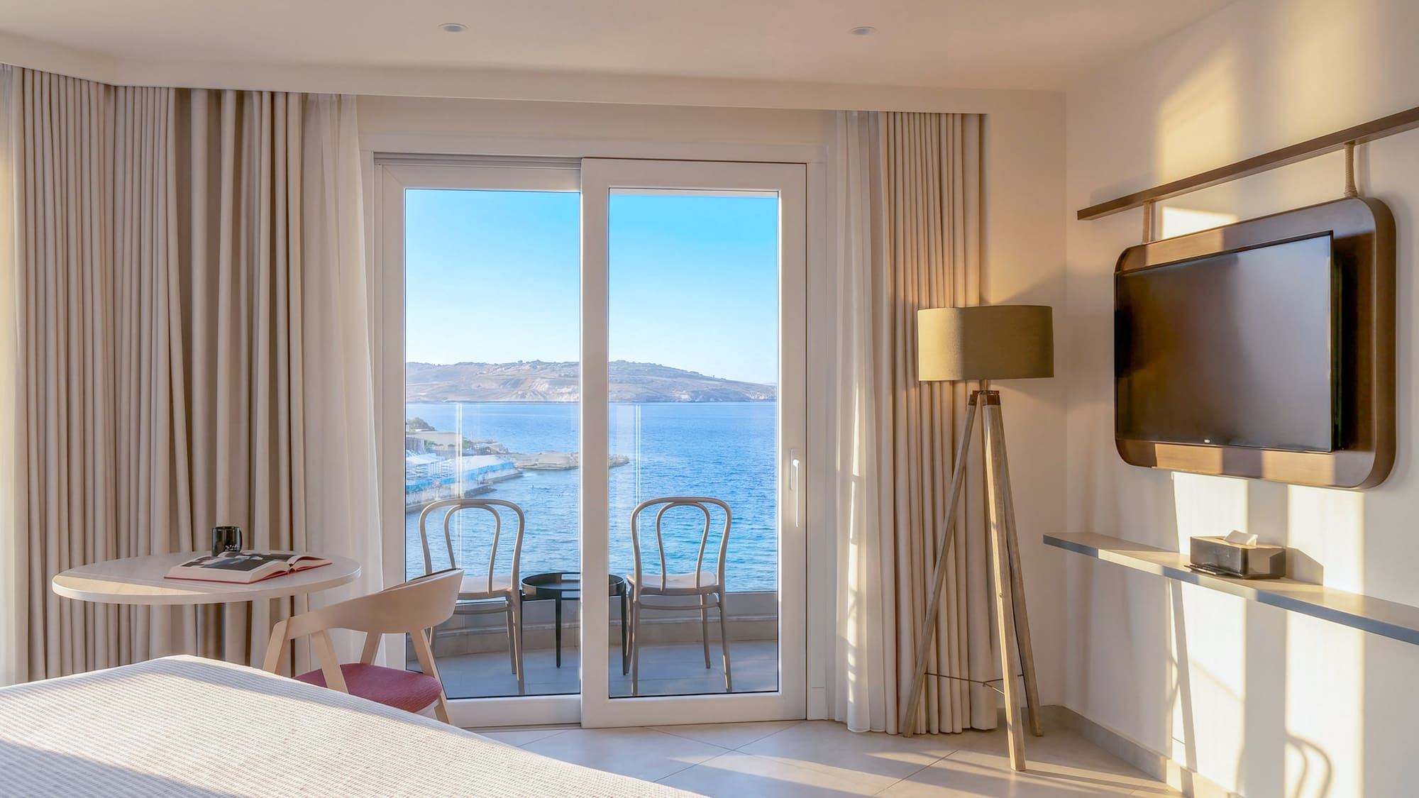 Hotel room with sea view balcony and modern interior design.