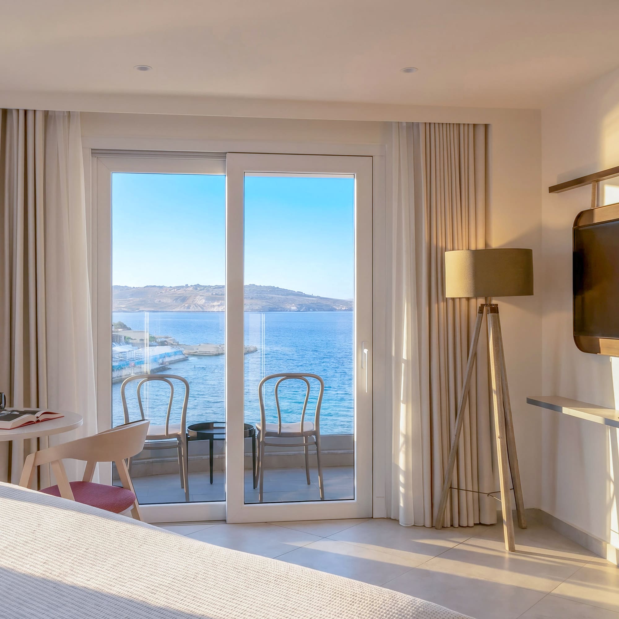 Hotel room with sea view balcony and modern interior design.