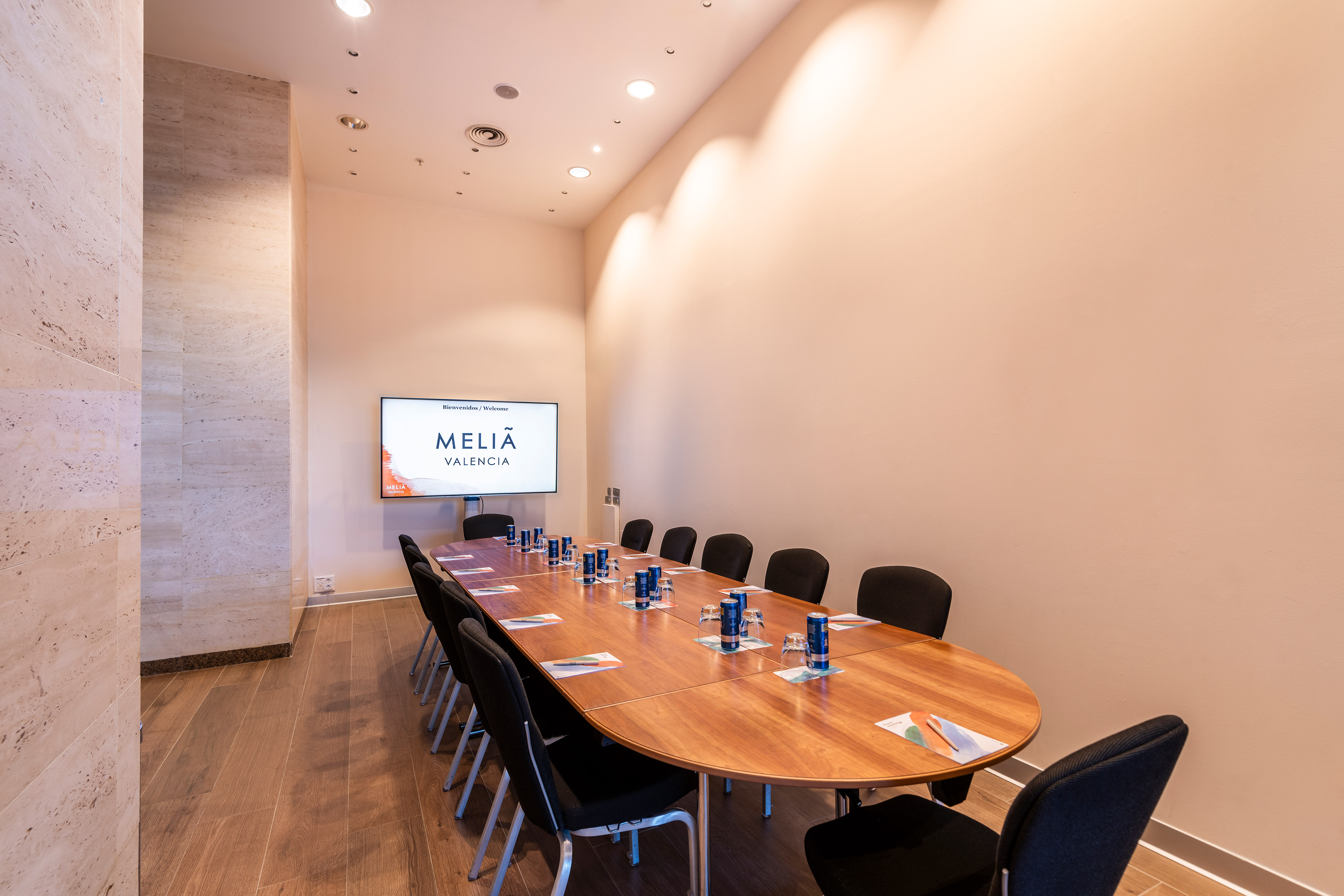Modern Meliã Valencia conference room with large wooden table and chairs.