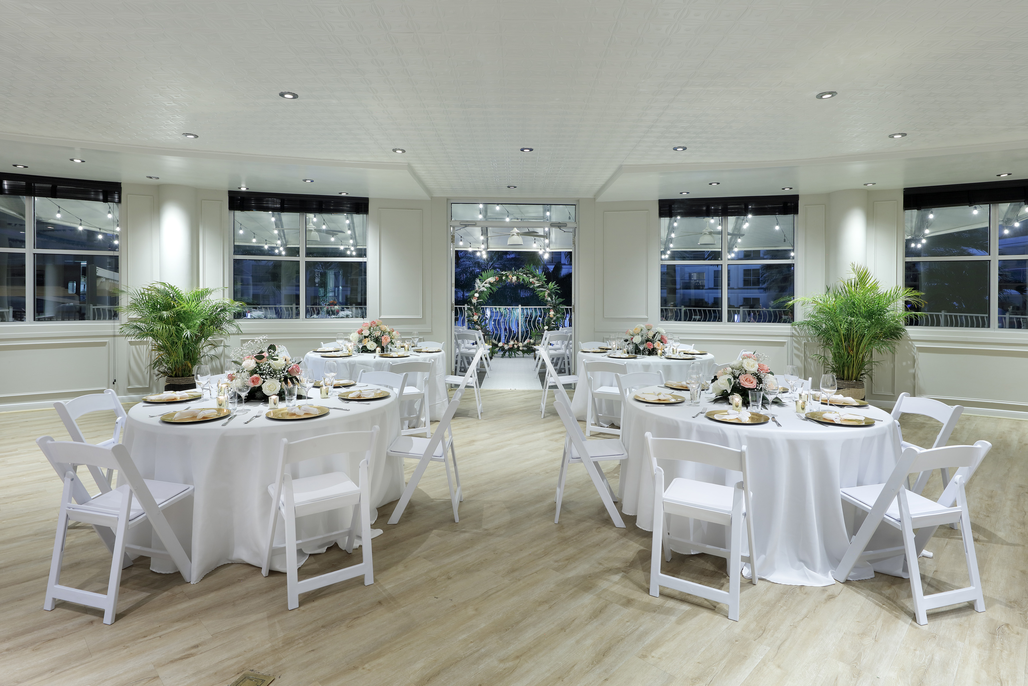 Elegant wedding reception hall with white tables, floral decor, string lights. - The Pearl (circular floor plan) - Meliá Orlando Celebration, Orlando