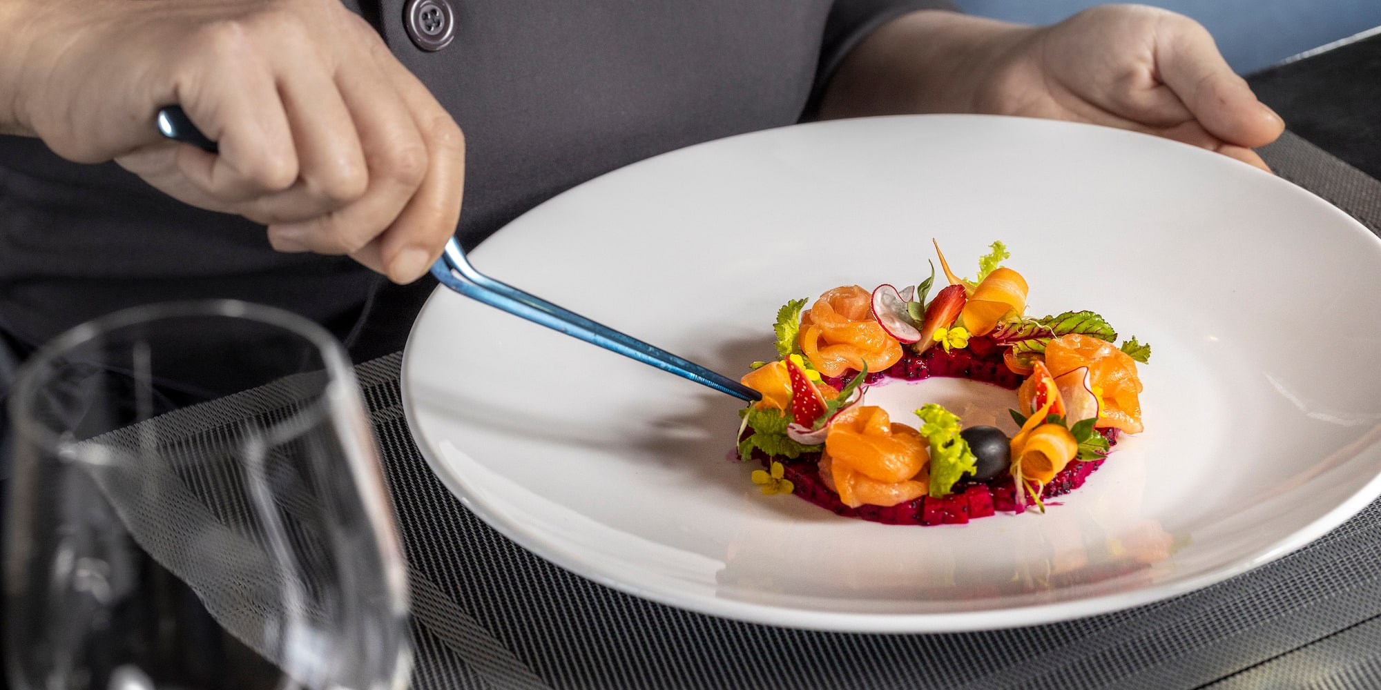 a person holding a fork over a plate of food